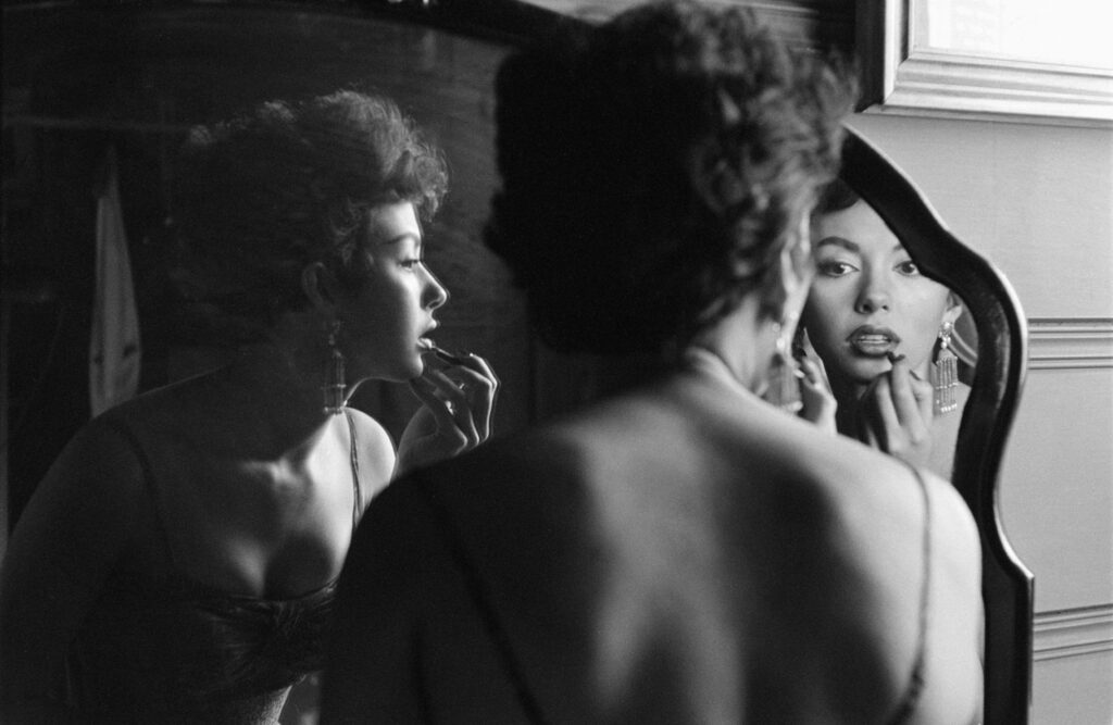 Rita Moreno Putting On Lipstick In Mirror, 1954