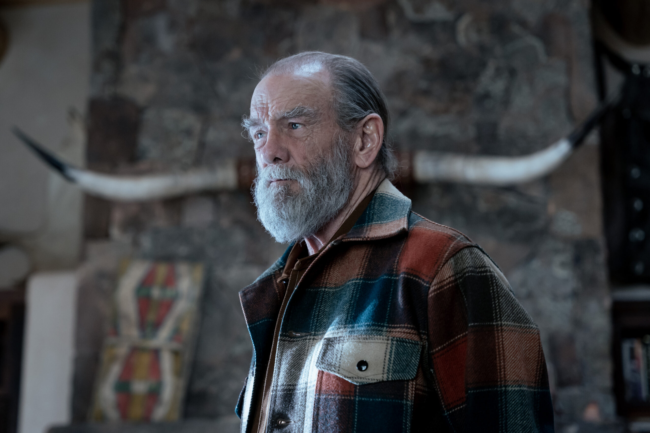 Dark Winds Season 2 Episode 6 - John Henry Diehl | Tell-Tale TV Still from Dark Winds Season 2 Episode 6 of John Henry Diehl as BJ Vines. Medium shot of him wearing a flannel jacket