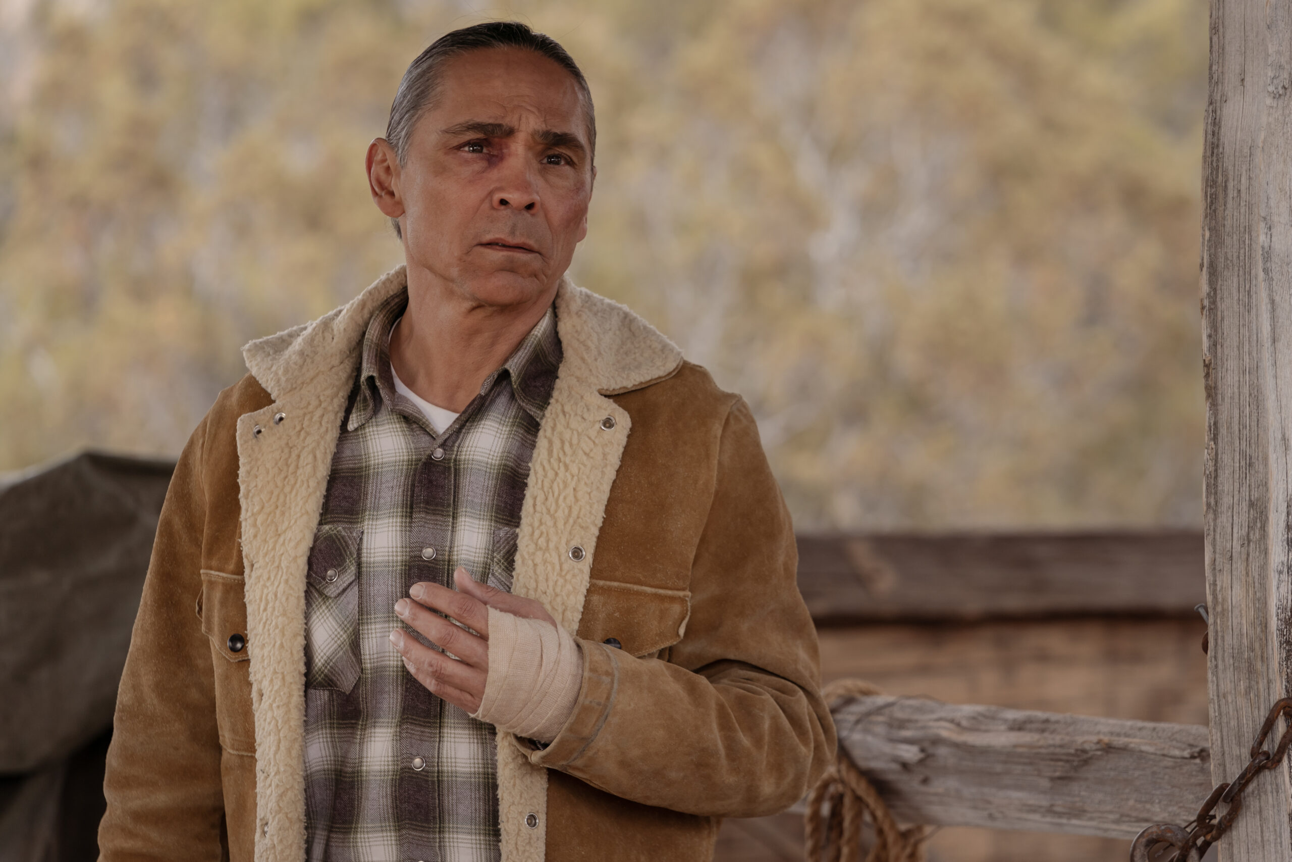 Dark Winds Season 2 Episode 6 - Zahn McClarnon | Tell-Tale TV Still from Dark Winds Season 2 Episode 6 of Zahn McClarnon as Joe Leaphorn. It's a medium shot of him with his hand bandaged