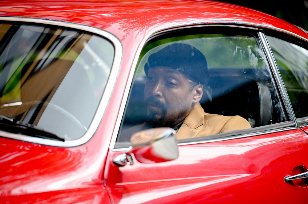 Still from The Irrational Season 1 Episode 1 of Jesse L. Martin as Alec Mercer sitting in a red car