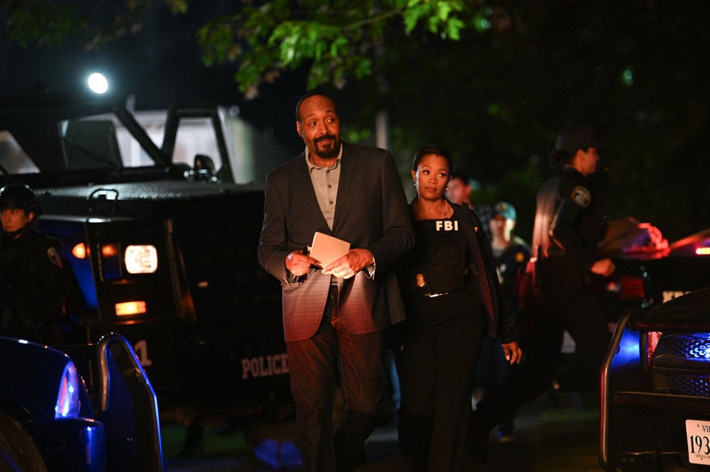 Still from The Irrational Season 1 Episode 1 of Jesse L. Martin and Maahra Hill standing together at an outdoor night time crime scene