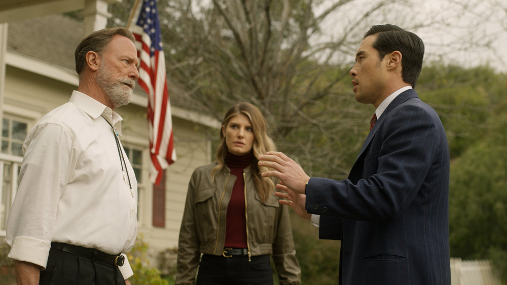 Still from Quantum Leap Season 2 Episode 3, "Closure Encounters," of Louis Herthum as Sheriff Woodrow Morgan, Caitlin Bassett as Addison, and Raymond Lee as Dr. Ben Song pictured from left to right.