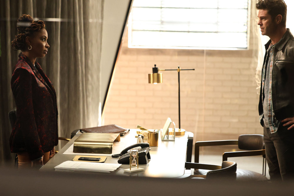 Still from Found Season 1 Episode 10 of Shanola Hampton as Gabi Mosely and Sterling Jones as Patrick Edwards pictured from left to right each standing on the opposite sides of a desk.