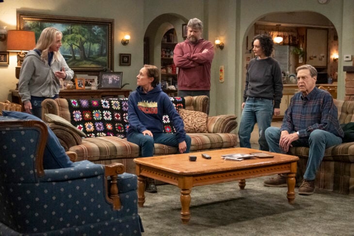 The Conners Season 6 Episode 3 - LECY GORANSON, LAURIE METCALF, JAY R. FERGUSON, SARA GILBERT, JOHN GOODMAN hanging out in the Conner home living room.