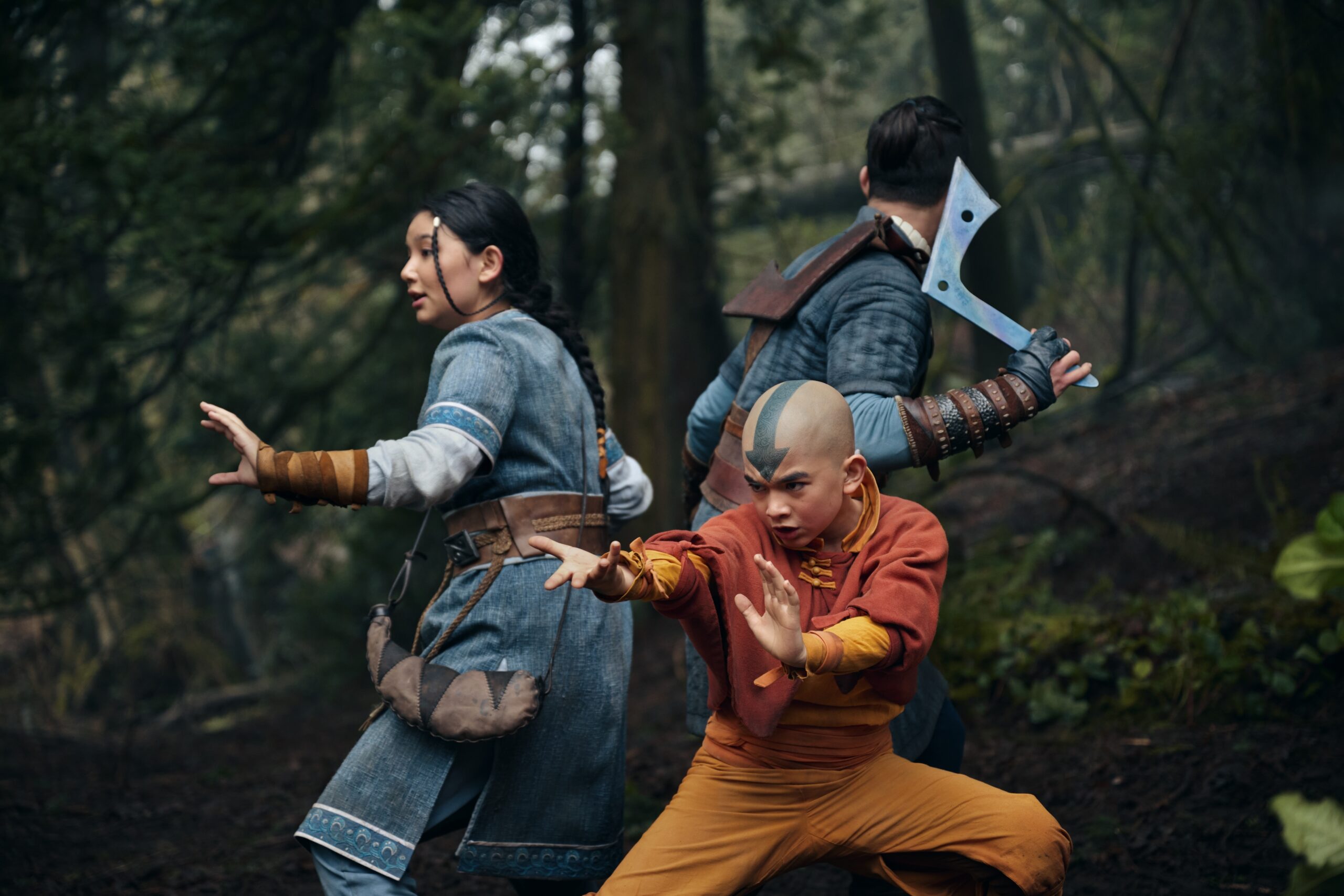 Still from the live action Netflix series Avatar: The Last Airbender of Kiawentiio as Katara, Gordon Cormier as Aang, and Ian Ousley as Sokka pictured from left to right.