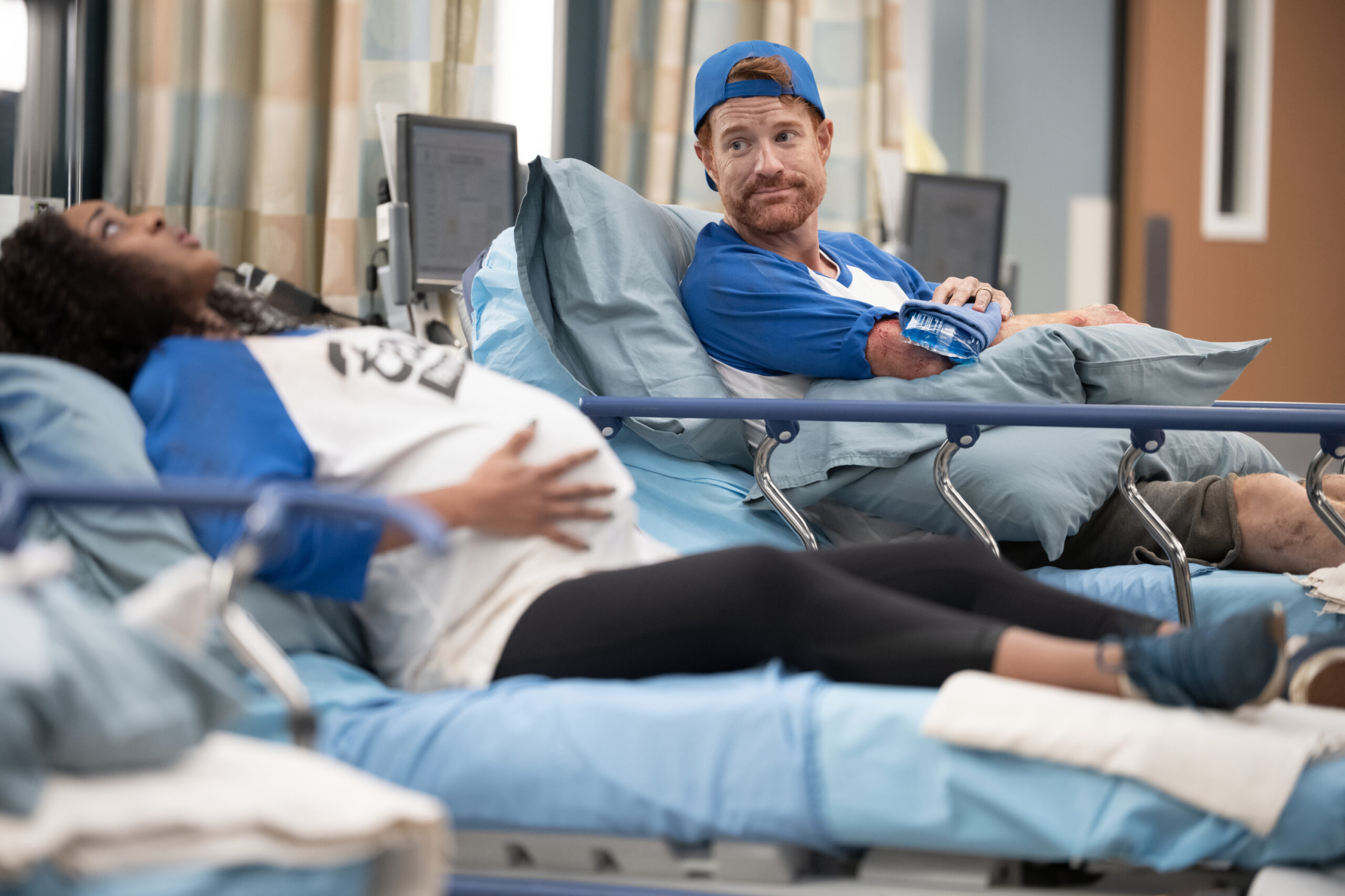 Two patients in the ER. One pregnant. Both wear baseball uniforms, on Grey's Anatomy Season 20 Episode 2, "Keep the Family Close." KIMBERLEY DRUMMOND, KASEY MAHAFFY