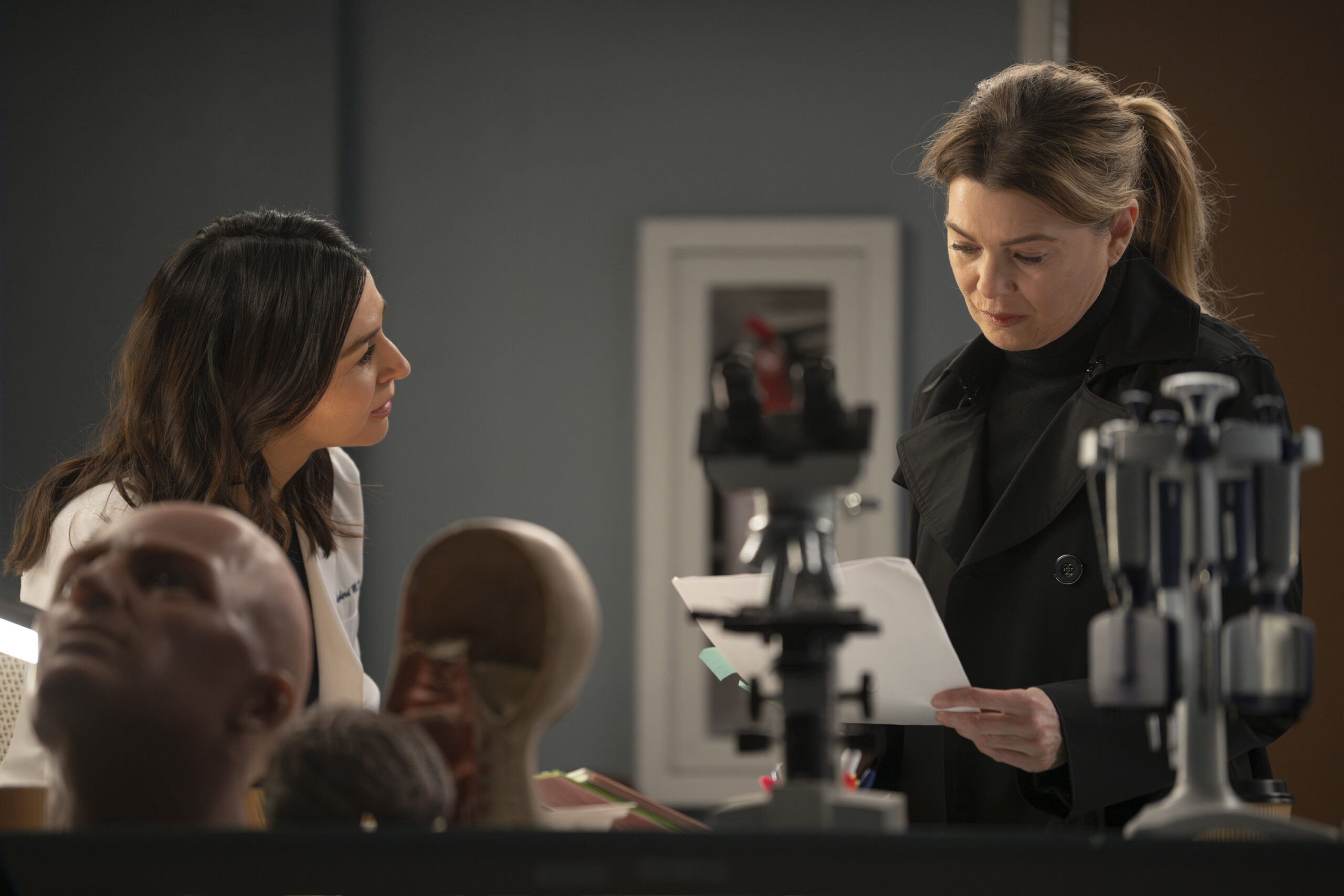Meredith and Amelia in the lab discussing research on Grey's Anatomy Season 20 Episode 3, "Walk the Ocean" - Caterina Scorsone as Amelia Shepherd, Ellen Pompeo as Meredith Grey