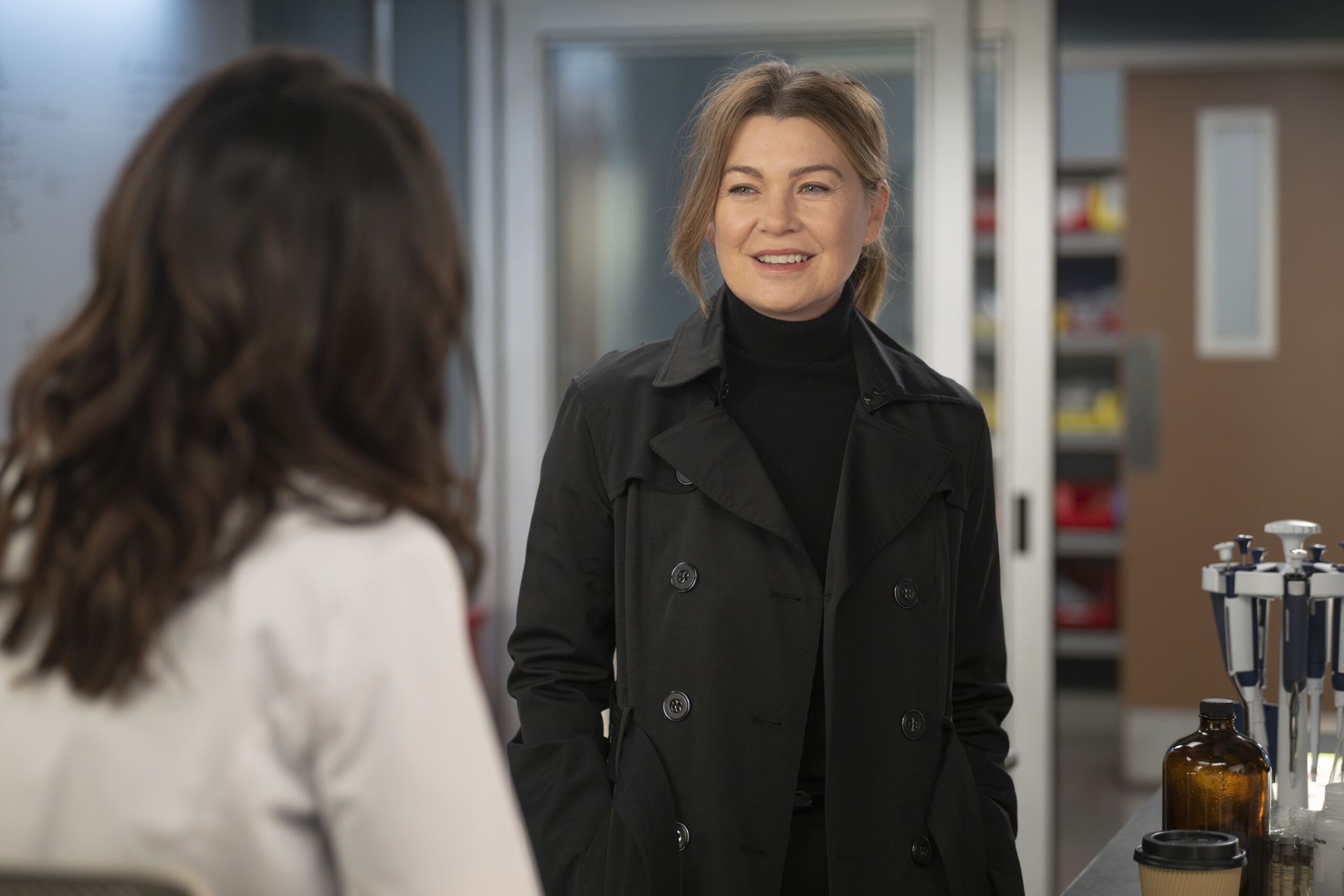 Meredith visits Amelia in the lab to discuss research on Grey's Anatomy Season 20 Episode 3, "Walk the Ocean" - Ellen Pompeo as Meredith Grey in a black jacket