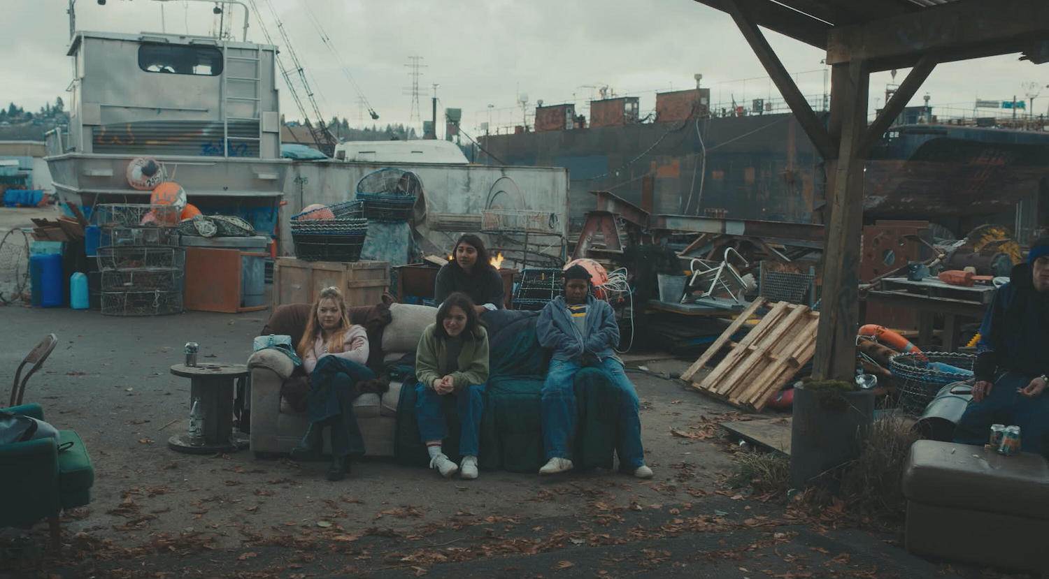 Under The Bridge Season 1 | Tell-Tale TV Under The Bridge Season 1CHLOE GUIDRY, IZZY G., VRITIKA GUPTA, AIYANA GOODFELLOW sitting on a couch in a junkyard