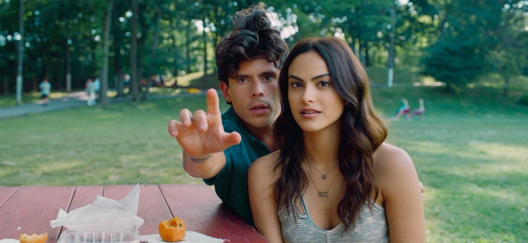 MUSICA Rudy Mancuso and Camila Mendes outside sitting on a park bench facing the camera