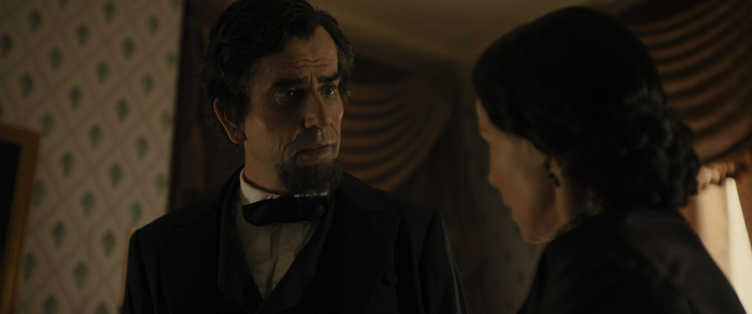 Manhunt Season 1 Episode 4 - Hamish Linklater and Lili Taylor | Tell-Tale TV Still from Manhunt Season 1 Episode 4 of Hamish Linklater as Abraham Lincoln and Lili Taylor Mary Todd Lincoln in a medium shot pictured from left to right.