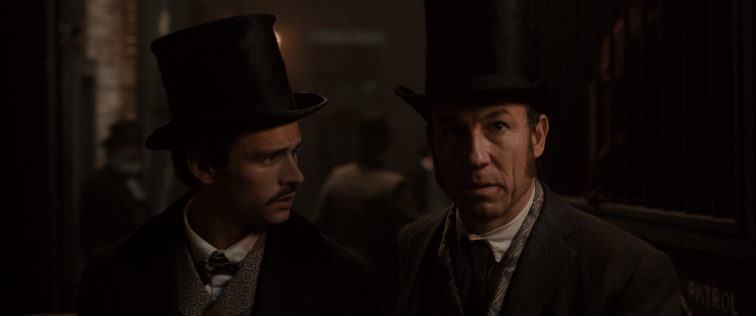 Manhunt Season 1 Episode 4 - Brandon Flynn and Tobias Menzies | Tell-Tale TV Still from Manhunt Season 1 Episode 4 of Brandon Flynn and Tobias Menzies in a medium shot pictured from left to right.