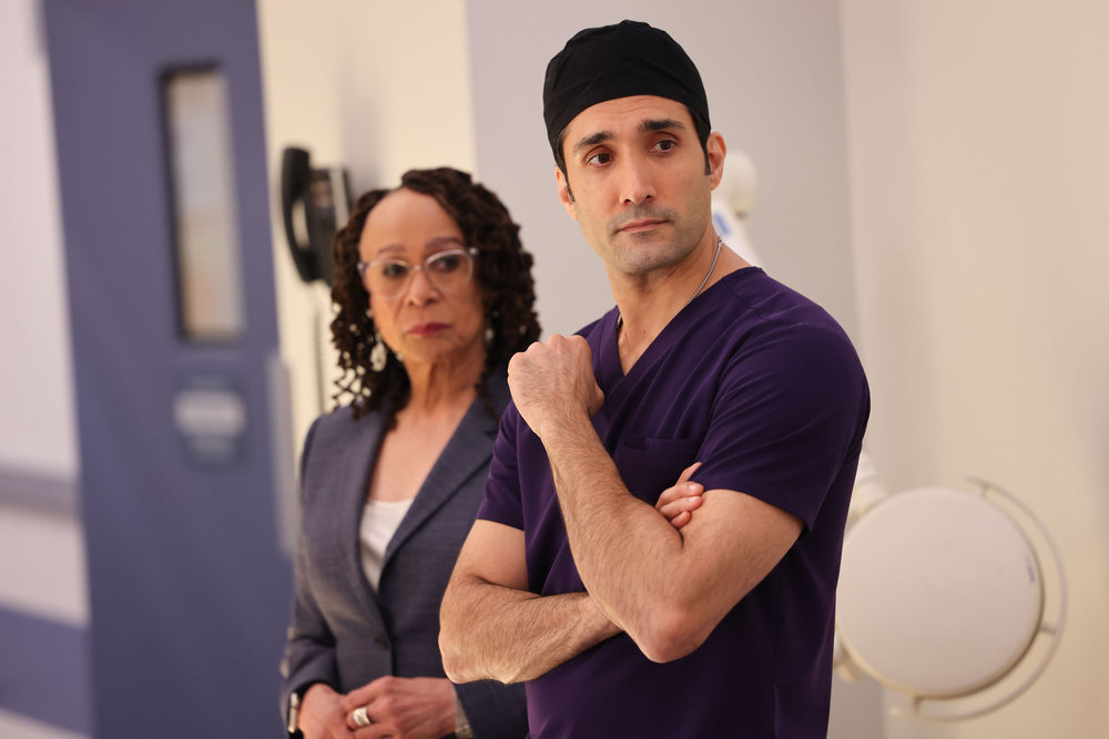 Chicago Med Season 9 Episode 7, S. Epatha Merkerson as Sharon Goodwin and Dominic Rains as Dr. Crockett Marcel stand side by side looking to something out of frame.