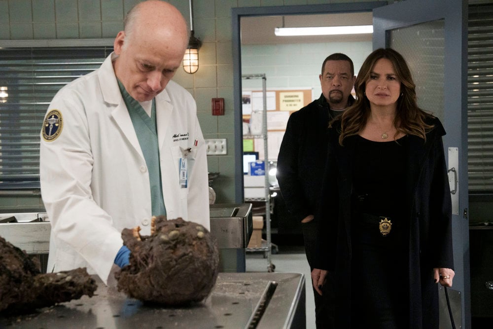 Law & Order: Special Victims Unit - Season 25 Episode 7, Frank Wood as M.E. Abel Truman shows his findings on a decomposing corpse to Ice T as Sgt. Odafin "Fin" Tutuola and Mariska Hargitay as Captain Olivia Benson.