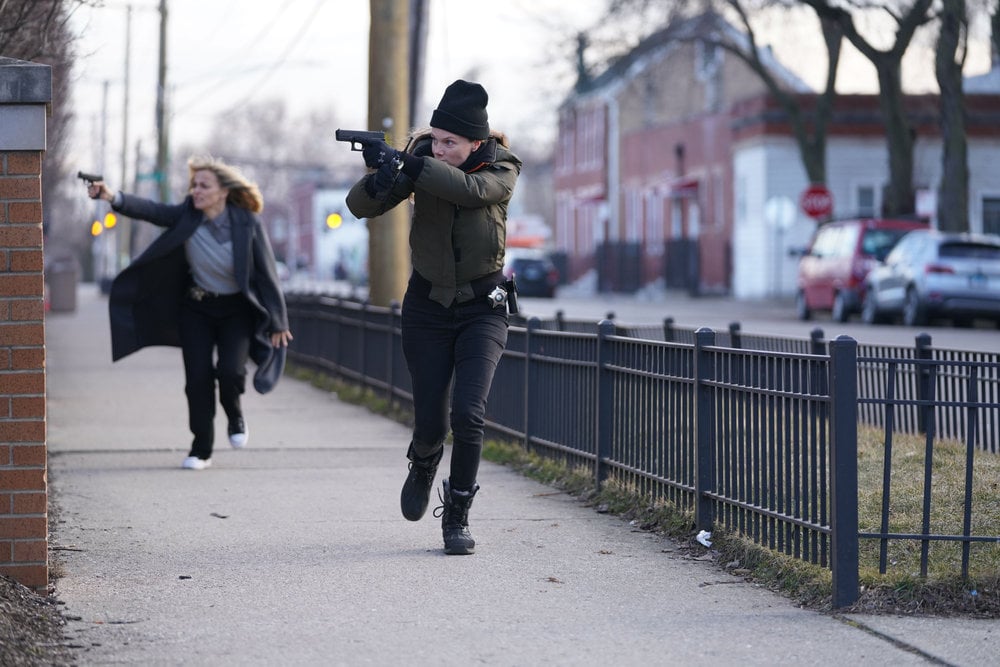 Chicago P.D. - Season 11 Episode 8 Bojana Novakovic runs a few paces behind Tracy Spiridakos as Hailey Upton. Both women have their guns drawn.