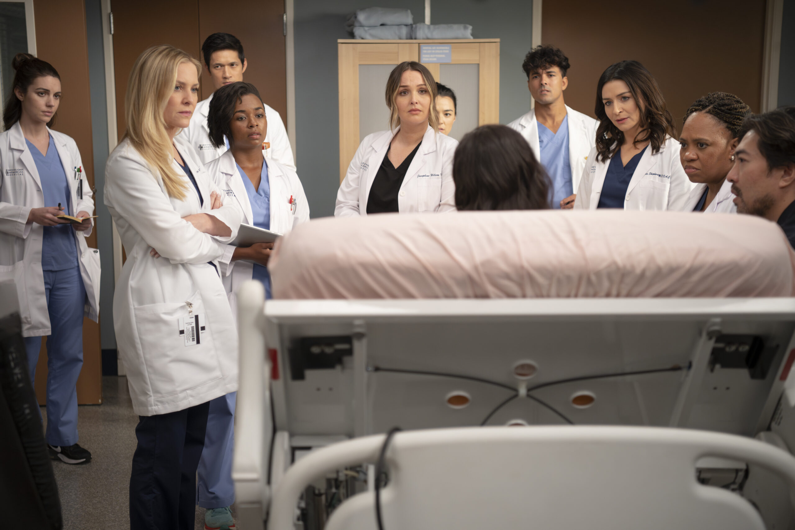 Arizona and a group of doctors speak to a patient on Grey's Anatomy Season 20 Episode 4 - ADELAIDE KANE, JESSICA CAPSHAW, HARRY SHUM JR., ALEXIS FLOYD, CAMILLA LUDDINGTON, MIDORI FRANCIS, NIKO TERHO, CATERINA SCORSONE, CHANDRA WILSON, DAVID CHAN