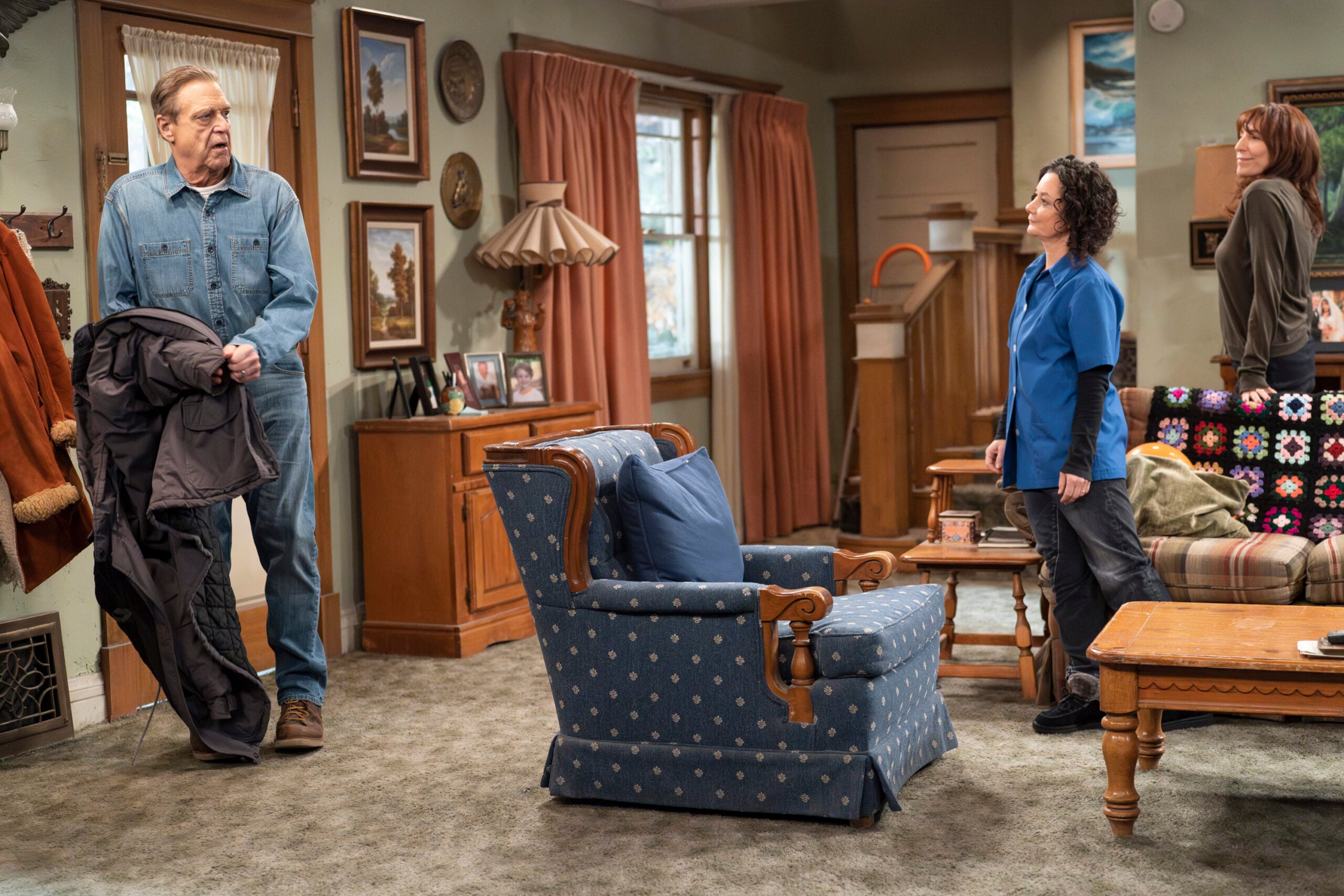 The Conners Season 6 Episode 8 - JOHN GOODMAN walks into the Conner living room to see SARA GILBERT, KATEY SAGAL standing there waiting for him.