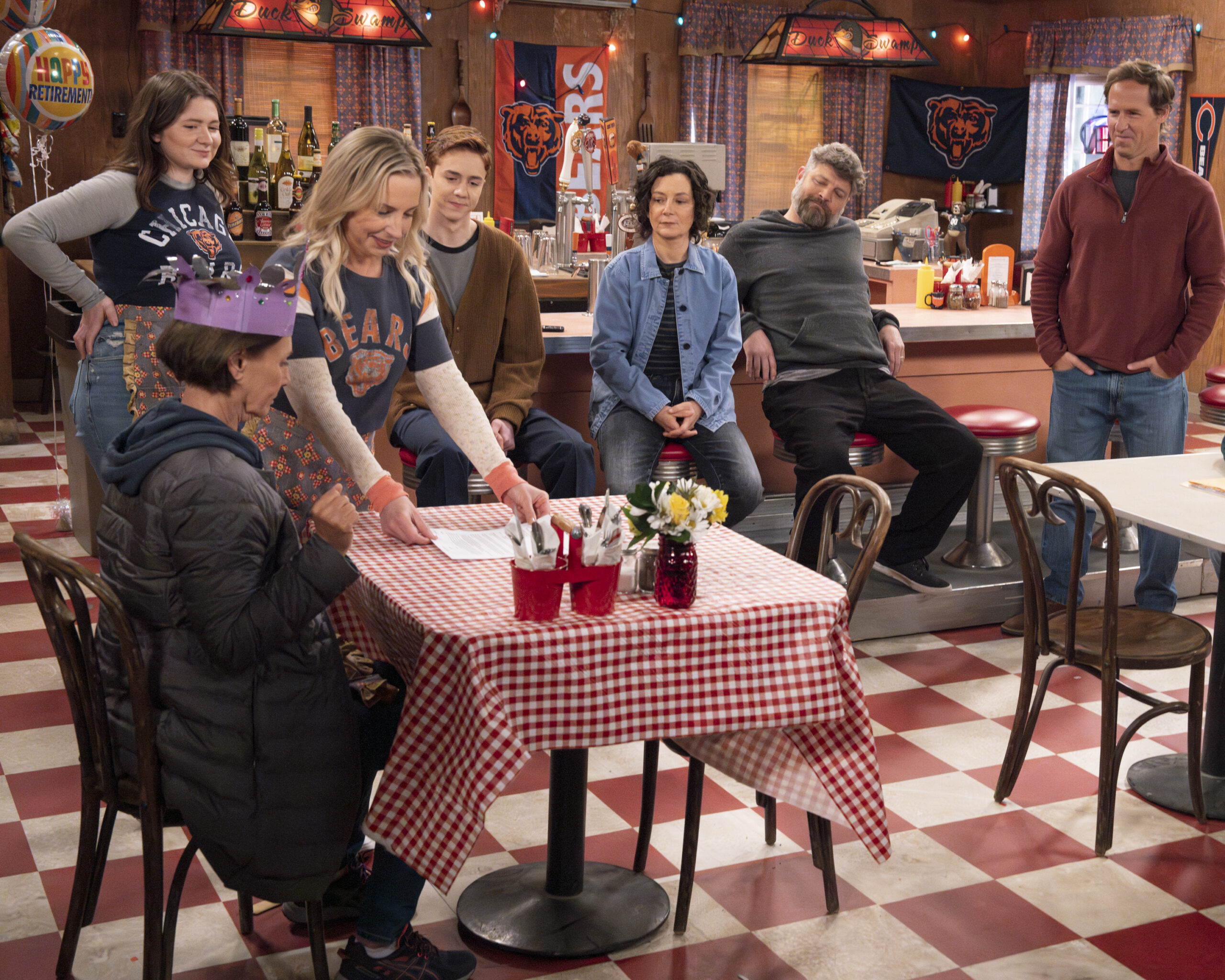 EMMA KENNEY, LAURIE METCALF, LECY GORANSON, AMES MCNAMARA, SARA GILBERT, JAY R. FERGUSON, NAT FAXON | Tell-Tale TV The Conners Season 6 Episode 10 - EMMA KENNEY, LAURIE METCALF, LECY GORANSON, AMES MCNAMARA, SARA GILBERT, JAY R. FERGUSON, and NAT FAXON gather at the Lunch Box for Jackie's retirement party.