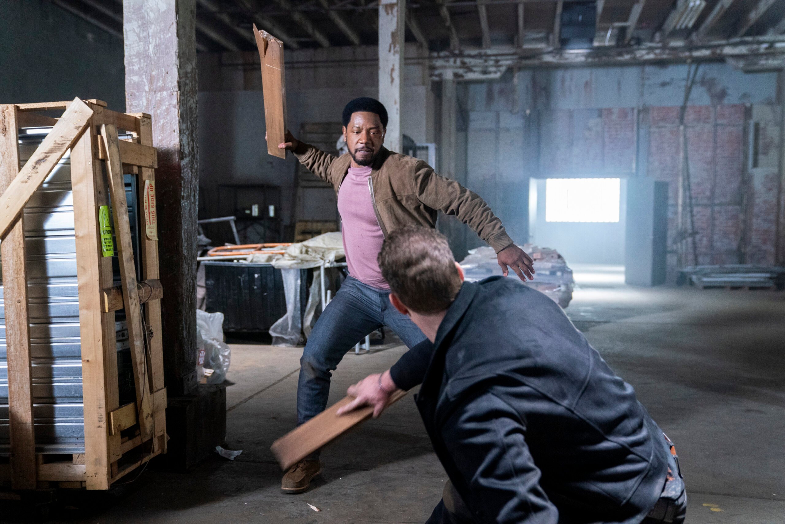 Dante hitting another man with a piece of wood.