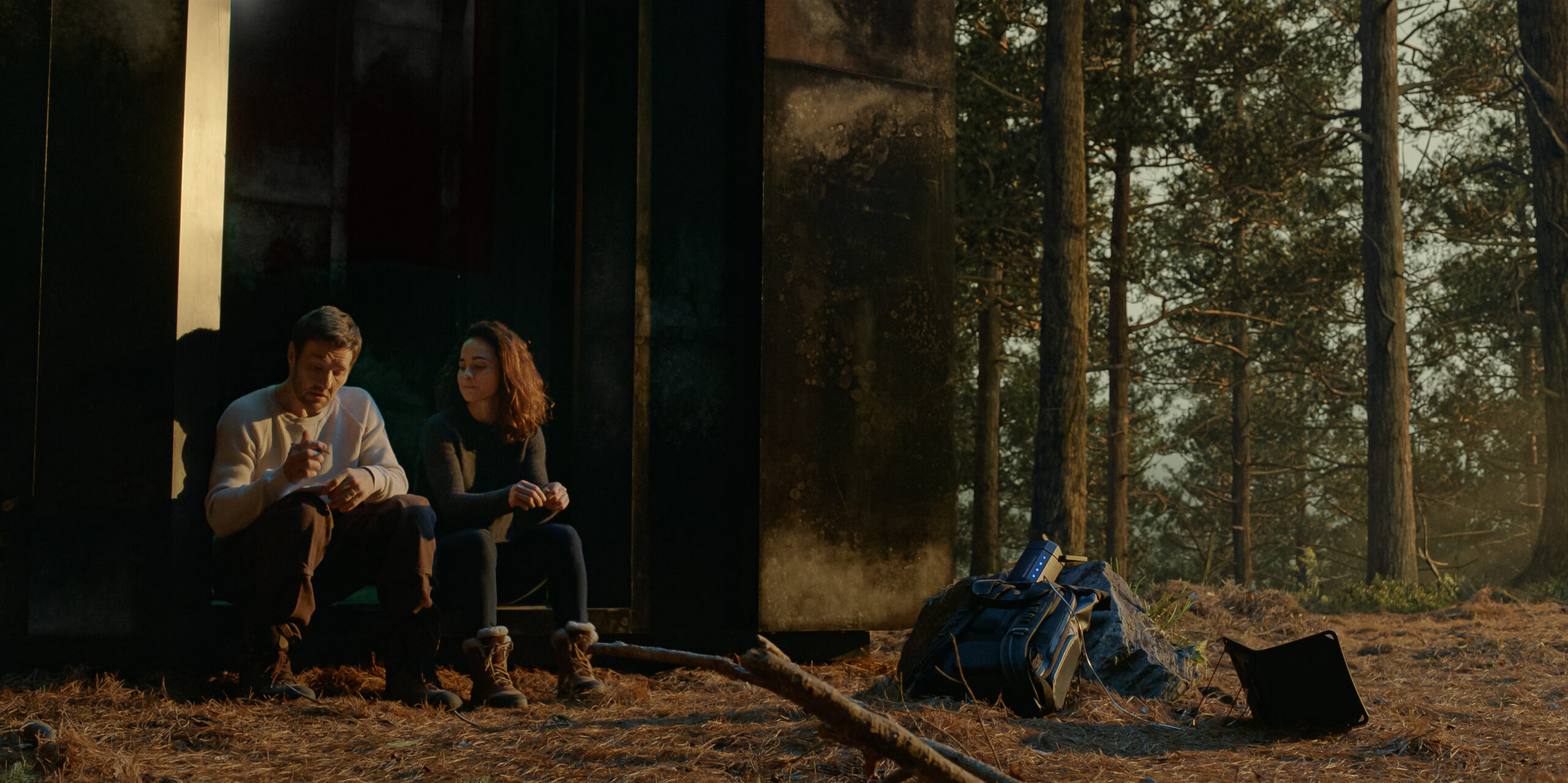 Dark Matter Season 1 Episode 6: Joel Edgerton and Alice Braga | Tell-Tale TV Still from Dark Matter Season 6 of Joel Edgerton and Alice Braga sitting in the woods pictured from left to right.