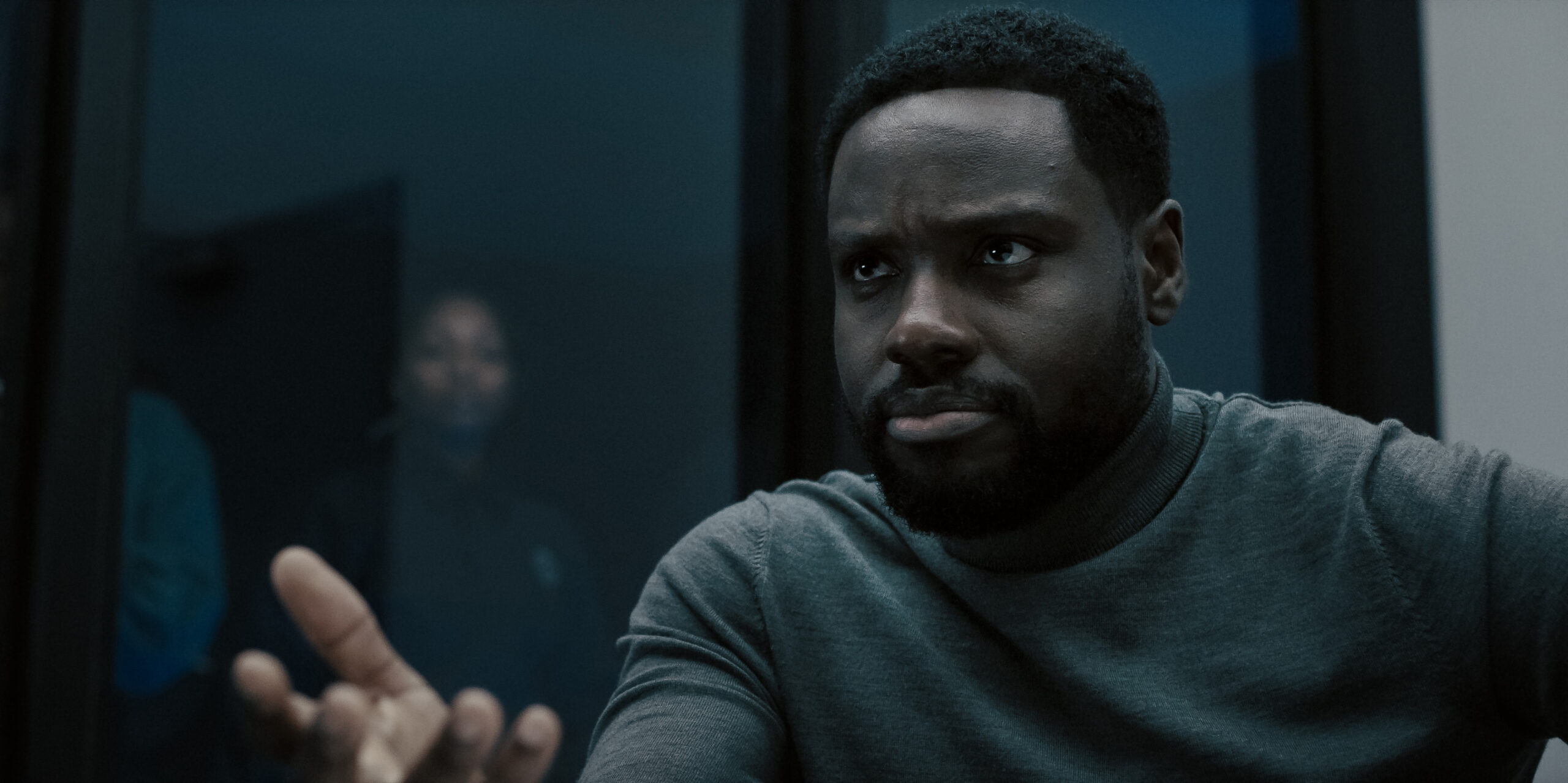 Dark Matter Season 1 Episode 1: Dayo Okeniyi | Tell-Tale TV Still from Dark Matter Season 1 Episode 1 of Dayo Okeniyi in a medium shot wearing a grey shirt.