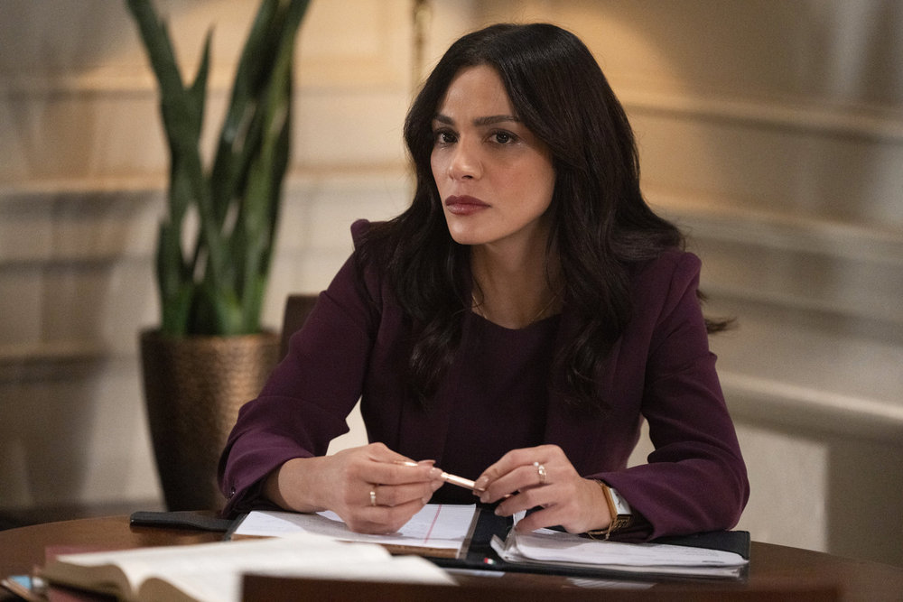 Law & Order Season 23 Episode 9 - Odelya Halevi as ADA Samantha Maroun sits looking pensive as she makes case notes.