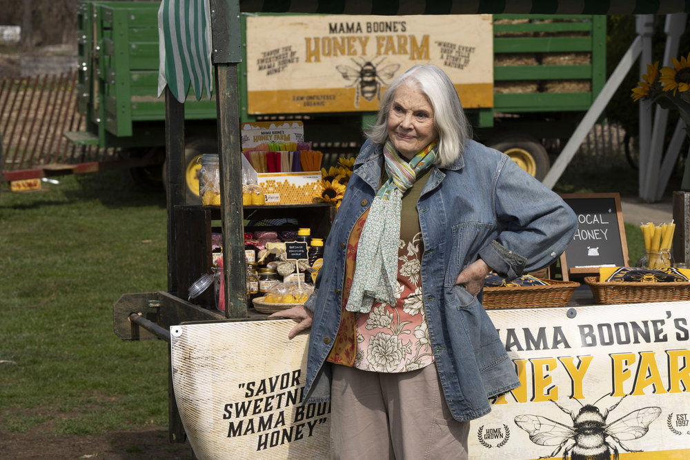 Law & Order: Organized Crime Season 4 Episode 9 - Lois Smith as Mama Boone stands in front of her roadside stand and smiles.