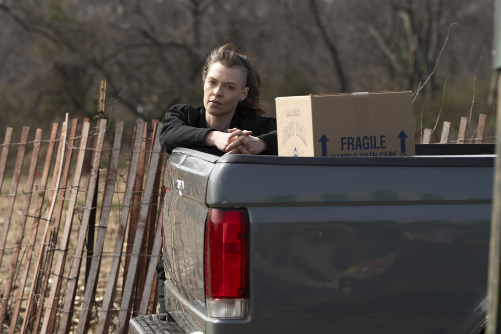 Law & Order: Organized Crime Season 4 Episode 9 - Rivera Reese as Trisha leans over the bed of a truck which contains boxes.