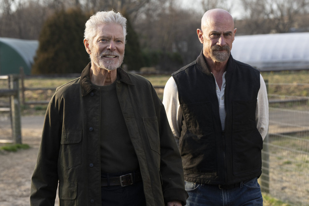 Law & Order: Organized Crime Season 4 Episode 9 - Stephan Lang as Angus Boone stands next to Christopher Meloni as Det. Elliot Stabler on a farm in the country.