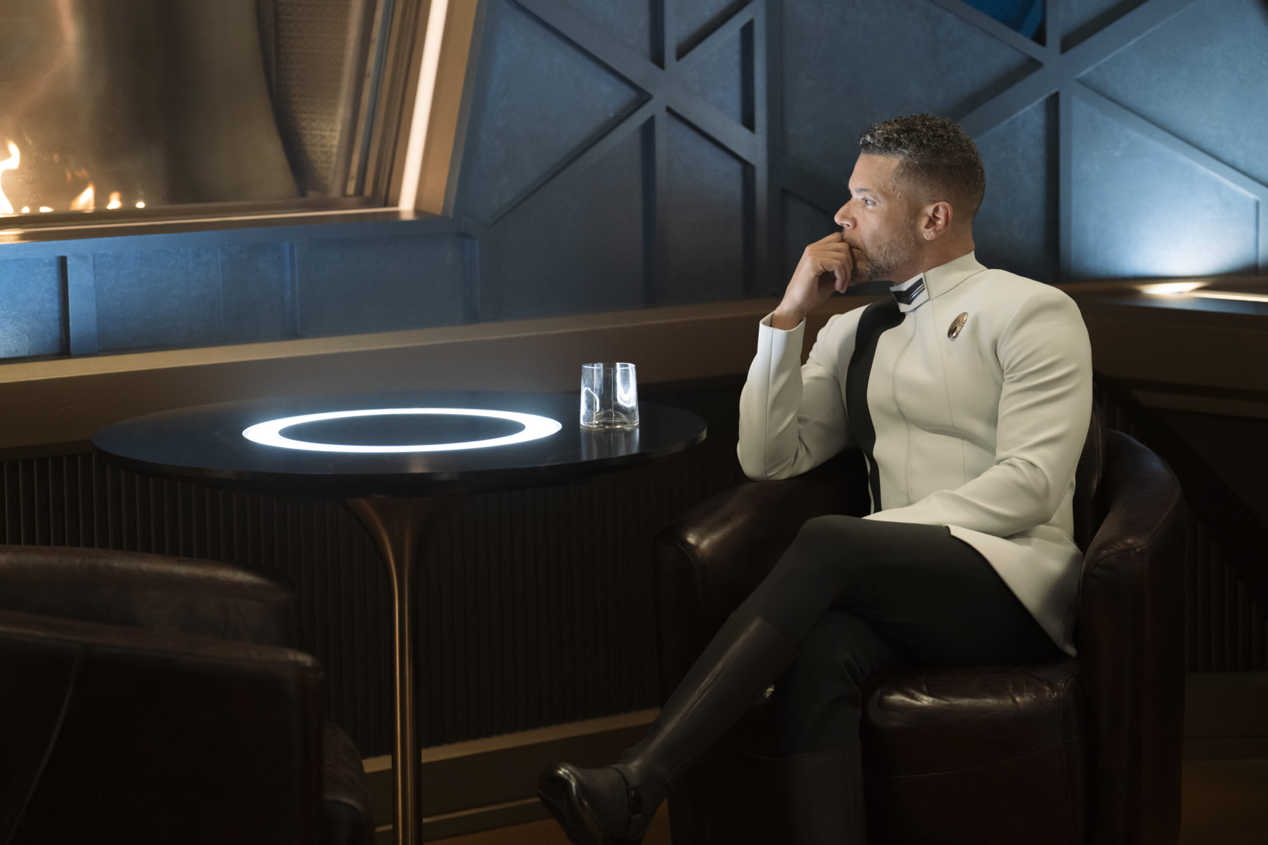 Star Trek: Discovery Season 5 Episode 3 Jinaal | Tell-Tale TV Dr. Culber sits in a lounge on the U.S.S. Discovery while looking lost in thought on Star Trek: Discovery Season 5 Episode 3, "Jinaal."