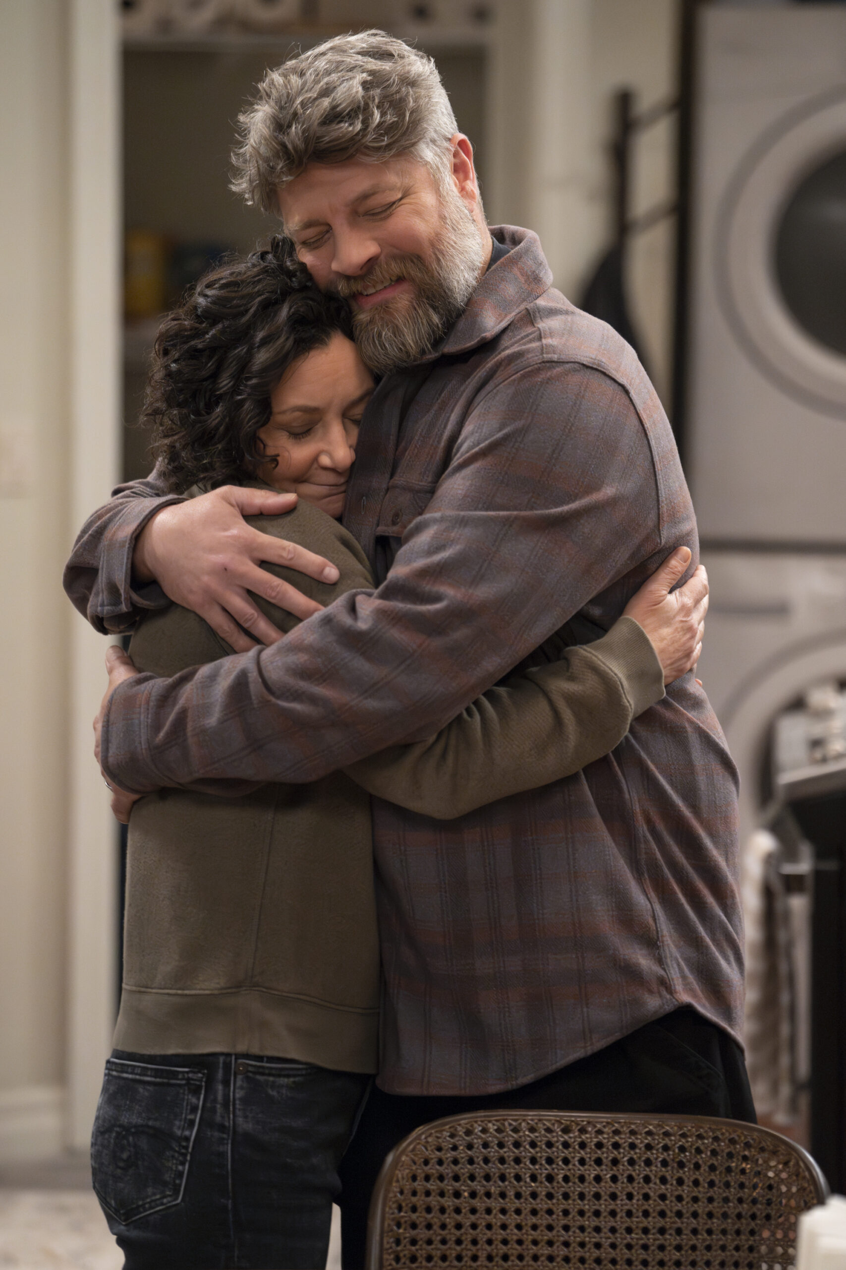 SARA GILBERT, JAY R. FERGUSON | Tell-Tale TV The Conners Season 6 Episode 11 SARA GILBERT and JAY R. FERGUSON hug deeply.