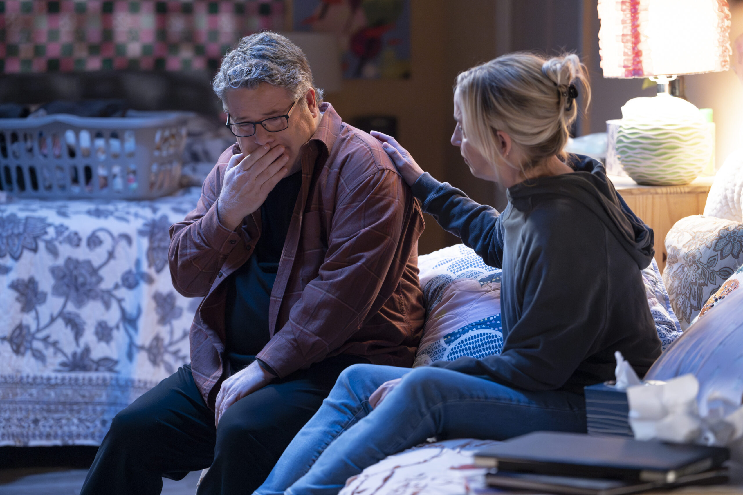 SEAN ASTIN, LECY GORANSON | Tell-Tale TV The Conners Season 6 Episode 11 SEAN ASTIN sits on the bed with LECY GORANSON both of them visibly emotional.