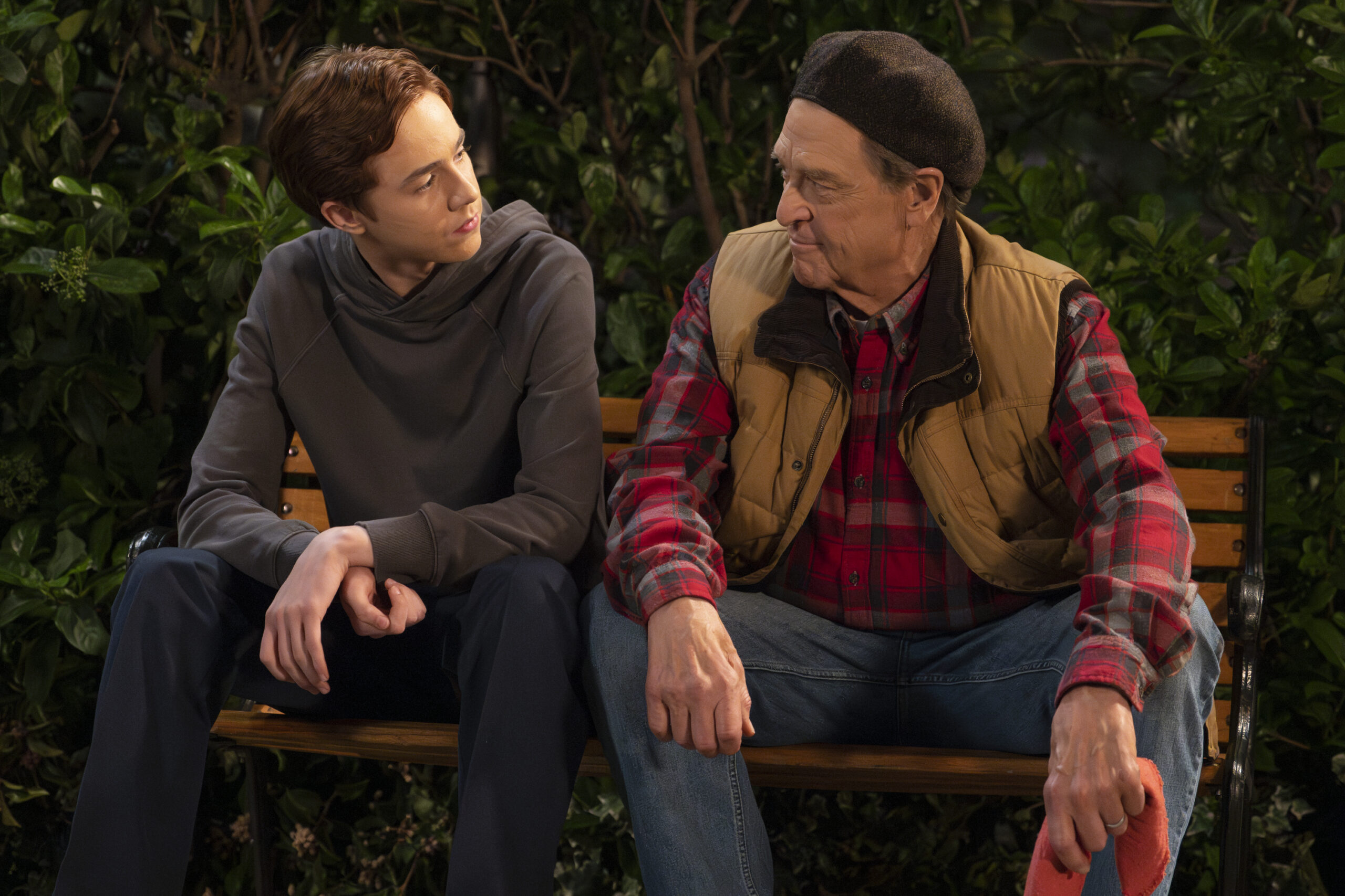 AMES MCNAMARA, JOHN GOODMAN | Tell-Tale TV The Conners Season 6 Episode 13 - AMES MCNAMARA sits on a park bench with JOHN GOODMAN sharing a heartfelt moment.