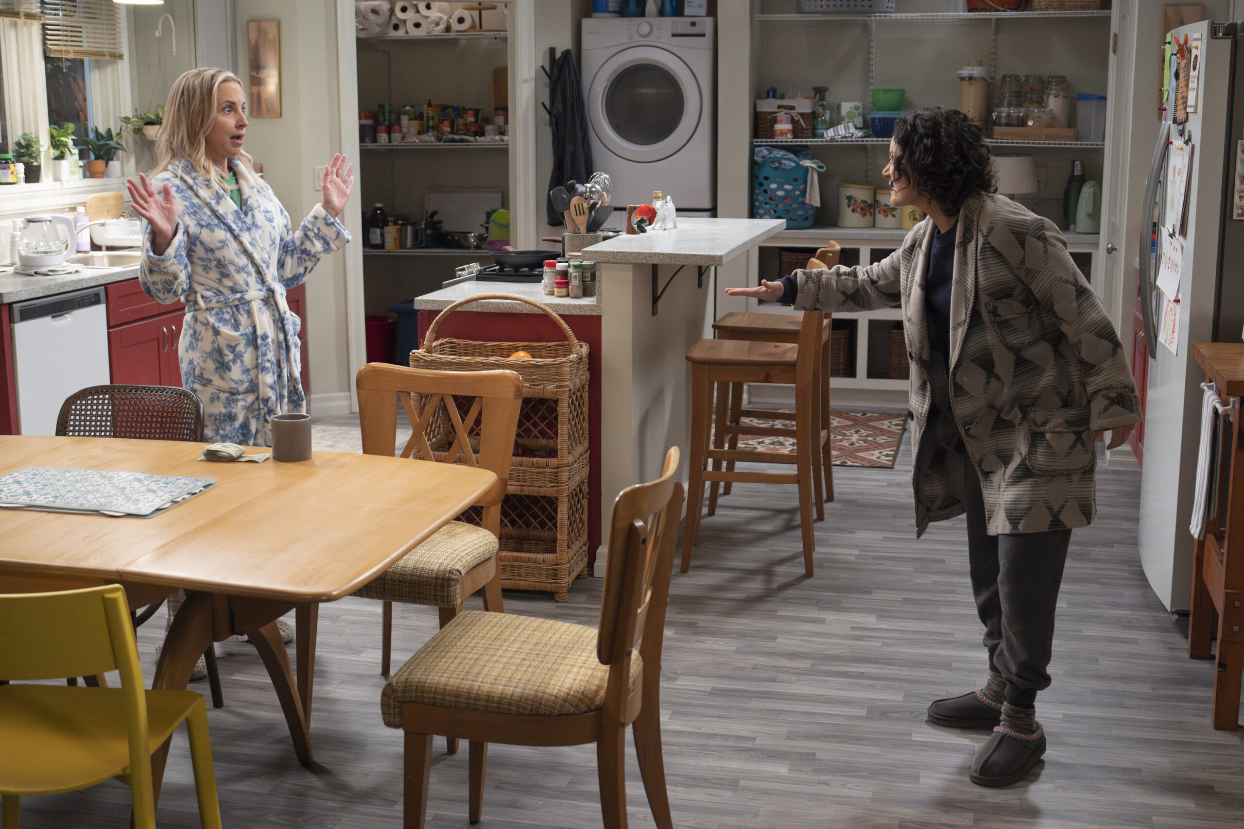 LECY GORANSON, SARA GILBERT | Tell-Tale TV The Conners Season 6 Episode 13 - LECY GORANSON and SARA GILBERT have a heated discussion, standing in their kitchen.