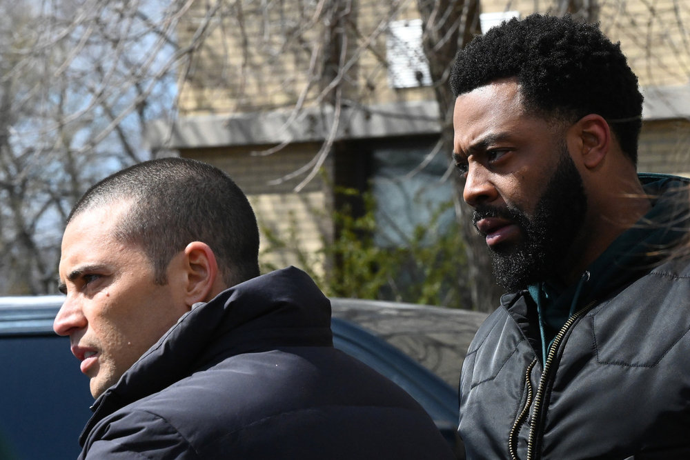 Chicago P.D. Season 11 Episode 12 - Benjamin Levy Aguilar as Dante Torres and LaRoyce Hawkins as Kevin Atwater stand together looking concerned.