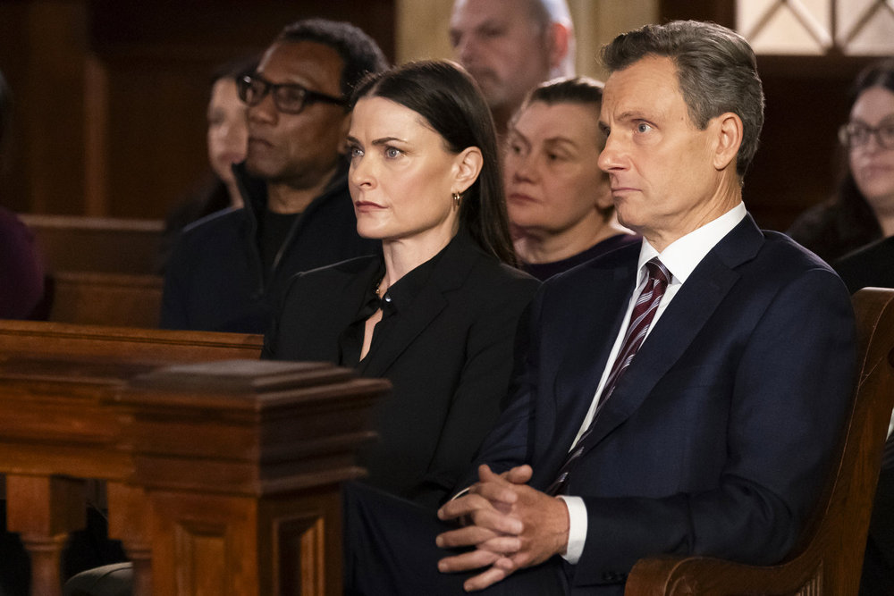 Law & Order Season 23 Episode 13 - Tara Westwood as Julia Baxter sits with Tony Goldwyn as DA Nicholas Baxter in court.