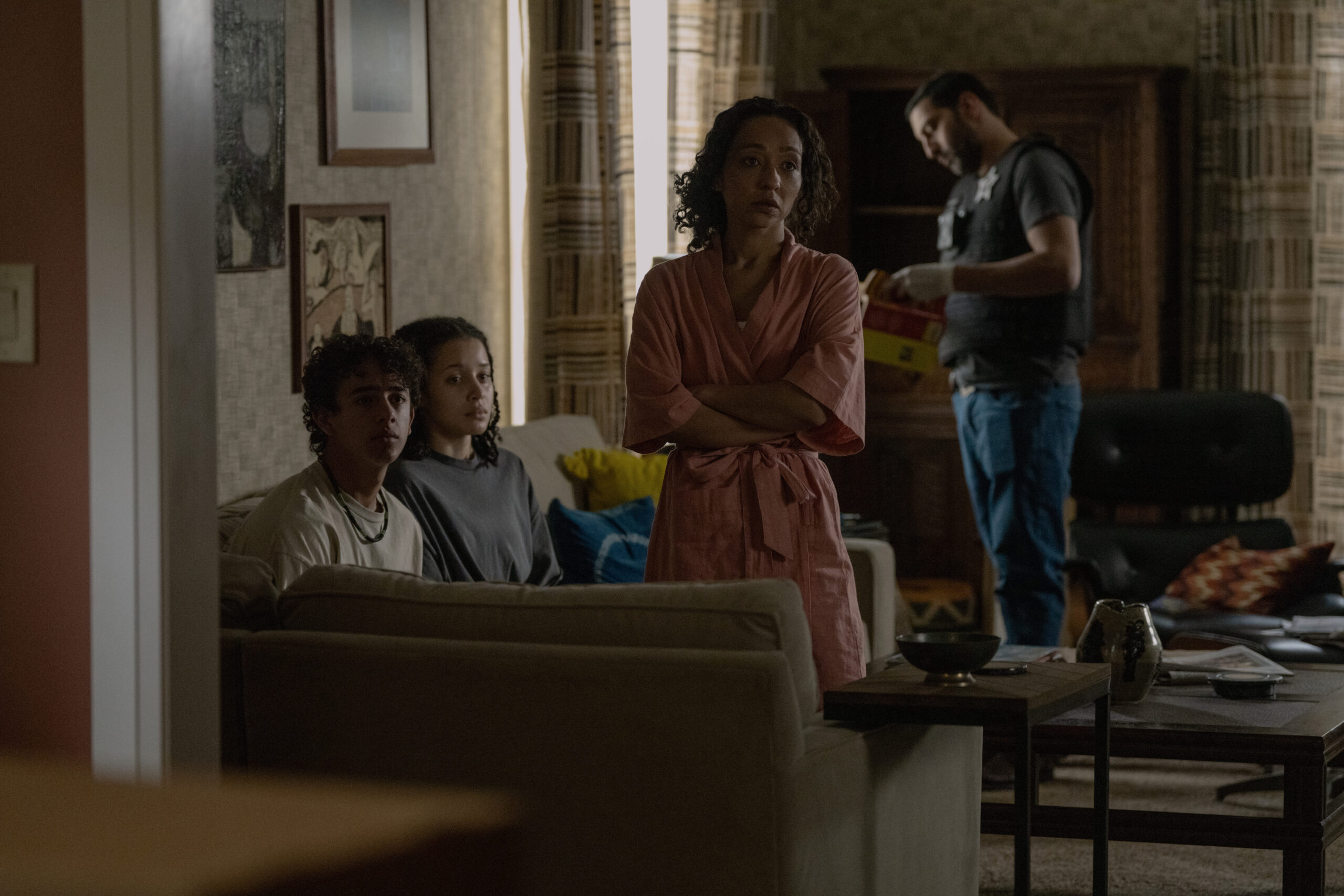 Ruth Negga, Chase Infiniti, and Kingston Rumi Southwick in the living room while the police looks around.