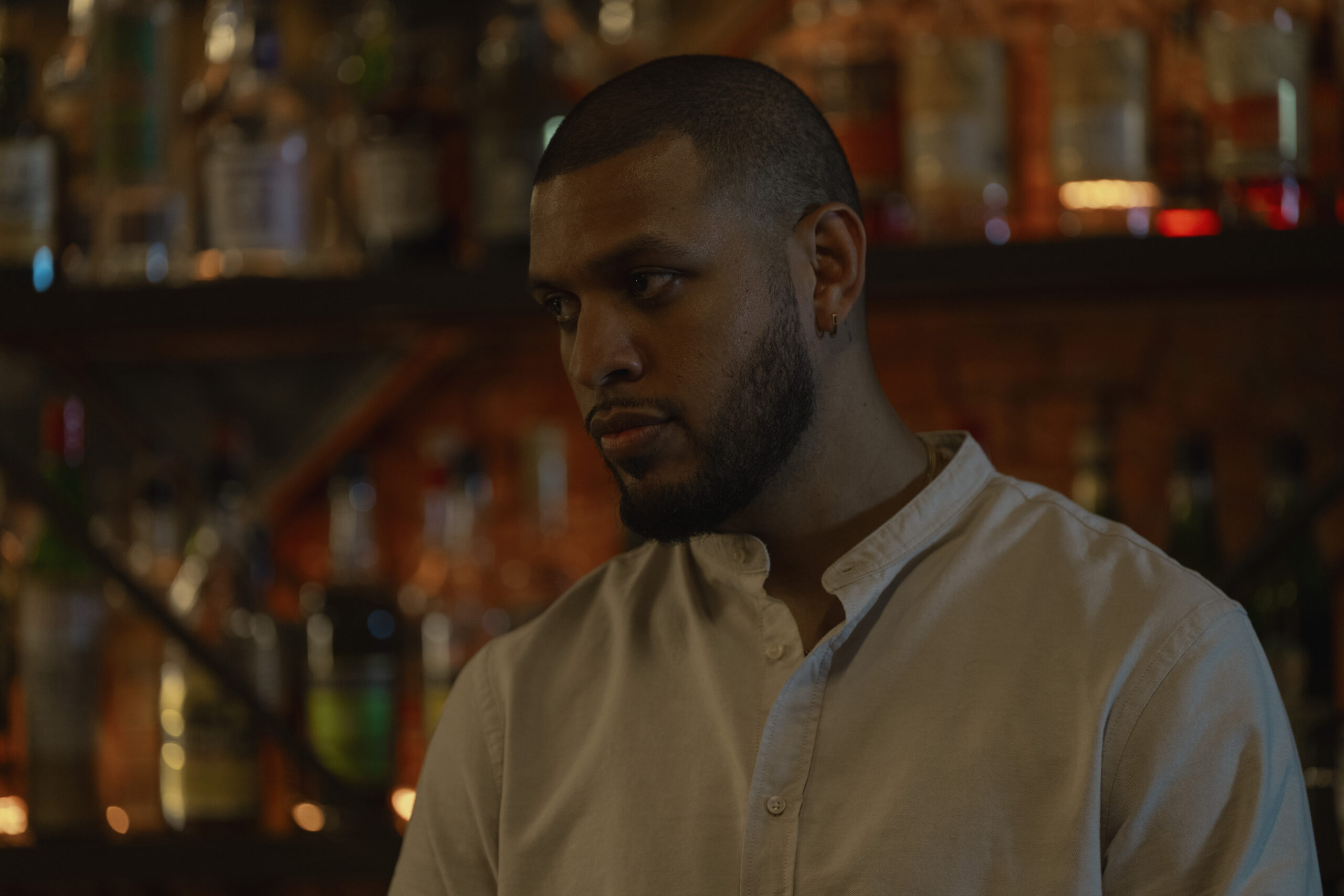 Sarunas J. Jackson standing in front of a liquor cabinet.