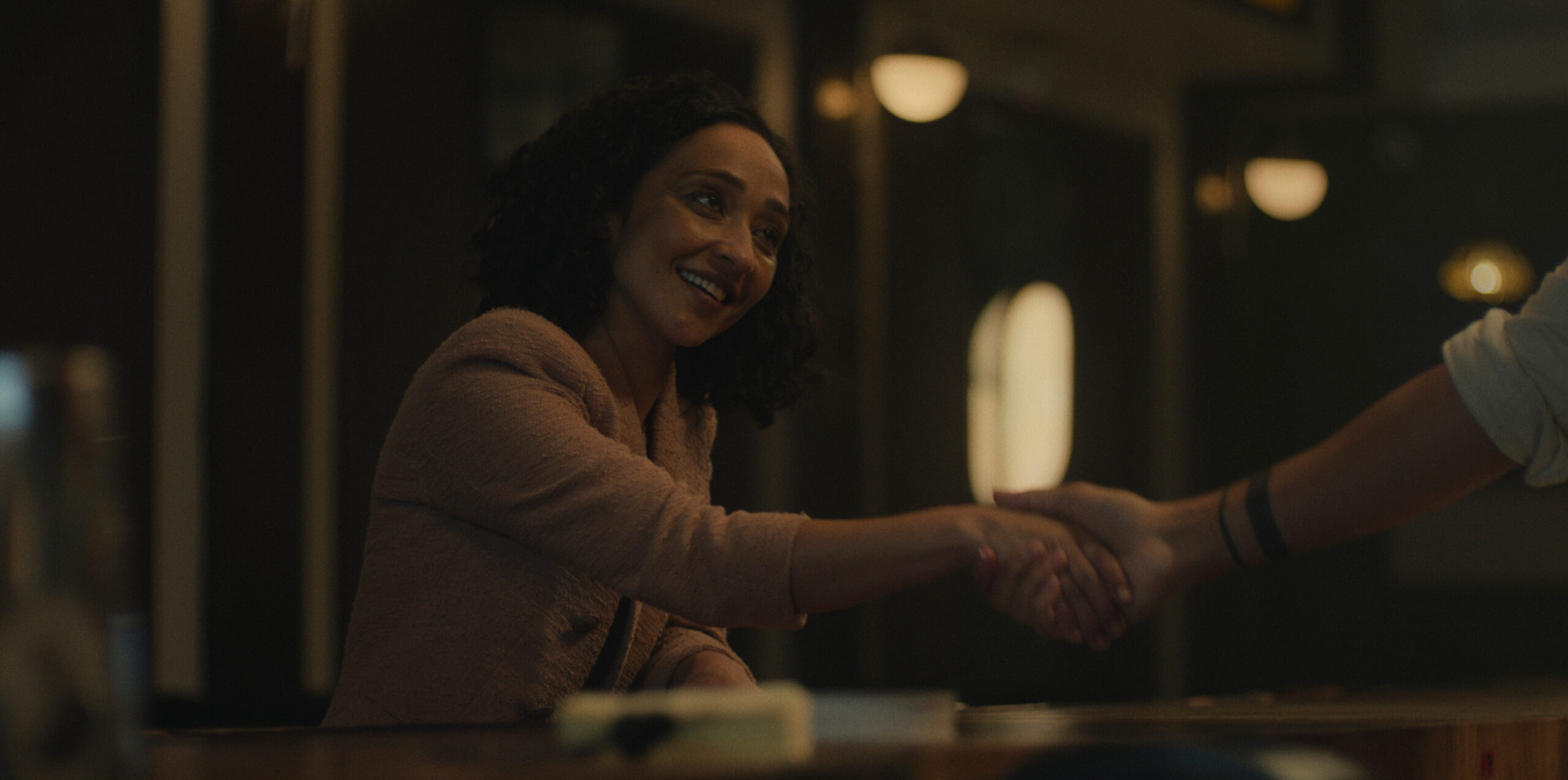 Ruth Negga shaking a man's hand.