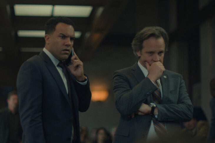 O-T Fagbenle and Peter Sarsgaard standing in court while Fagbenle talks on the phone.