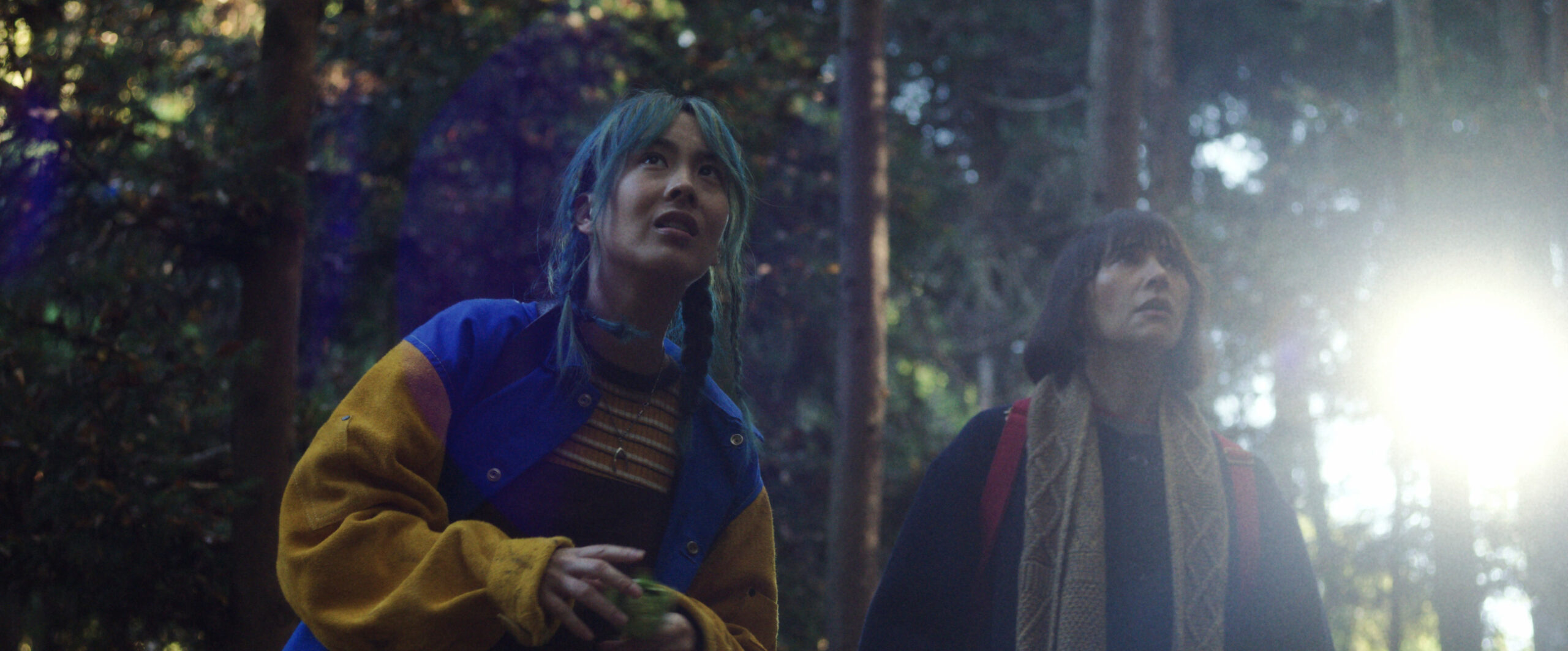 Mixxy and Suzie stand in the woods as daylight spills through the trees. They look focused on Sunny Season 1 Episode 5, "Joey Sakamoto."