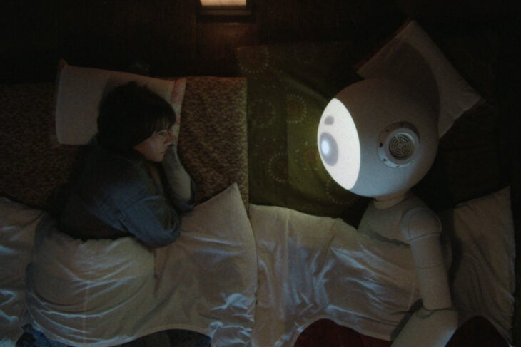 Suzie lies in bed, facing her robot Sunny, on Sunny Season 1 Episode 5, "Joey Sakamoto."
