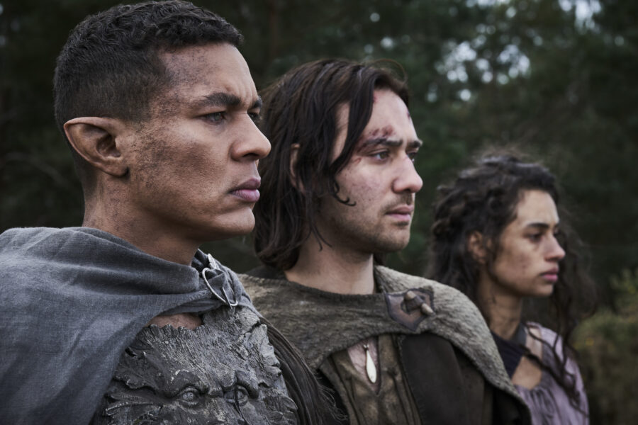 The Lord of the Rings: The Rings of Power Season 2 of Ismael Cruz Córdova as Arondir, Maxim Baldry as Isildur, and Nia Towle as Estrid pictured from left to right.