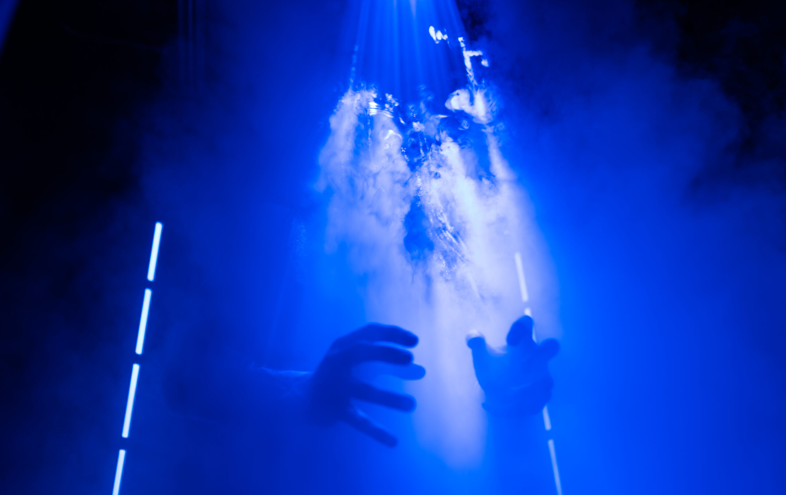 Still from Snowpiercer Season 4 Episode 5 of Daveed Diggs obscured by blue light and steam with only his hands visible.