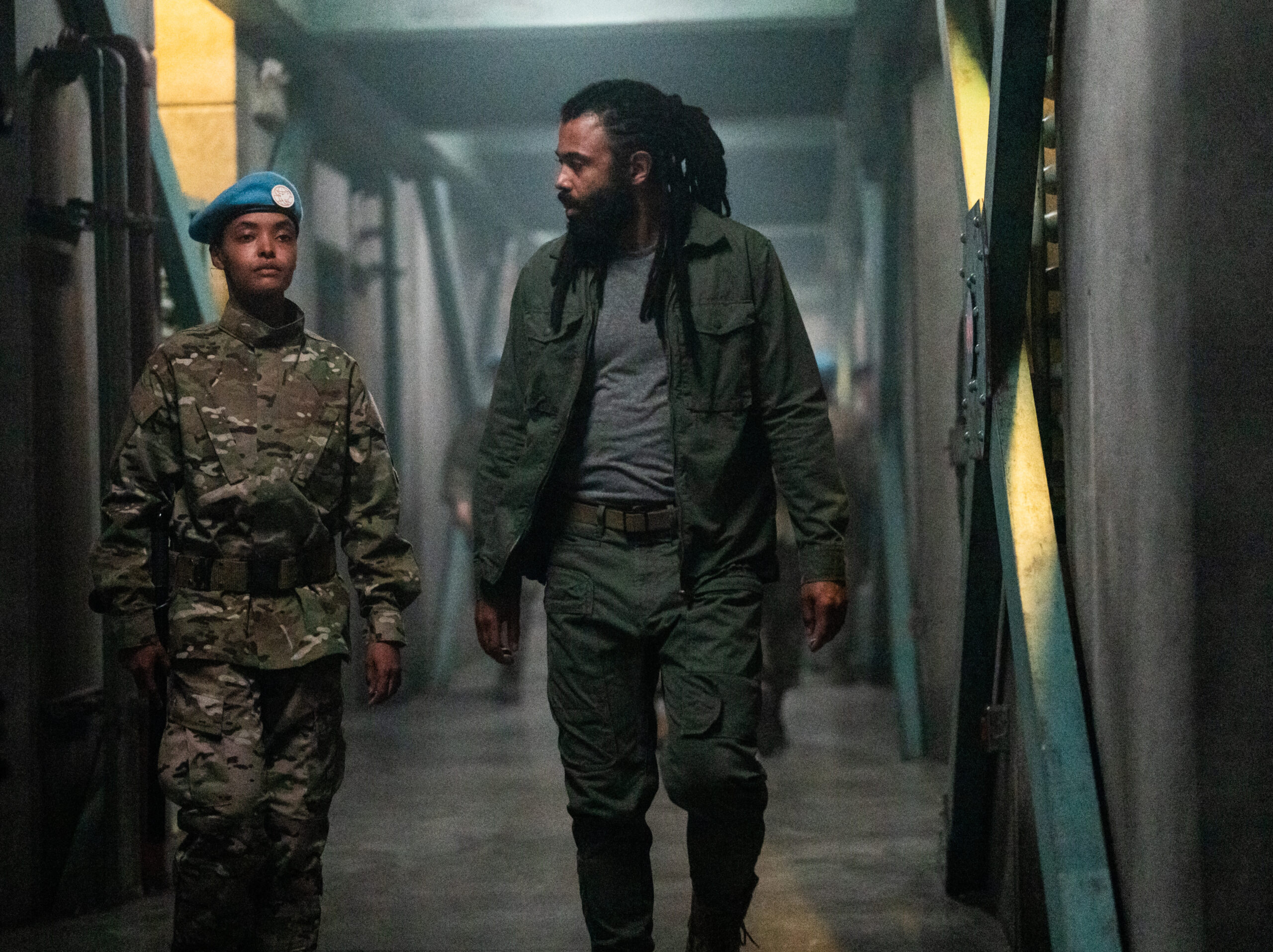 Still from Snowpiercer Season 4 Episode 5 of Daveed Diggs walking down a hallway with a woman dressed in military camo.