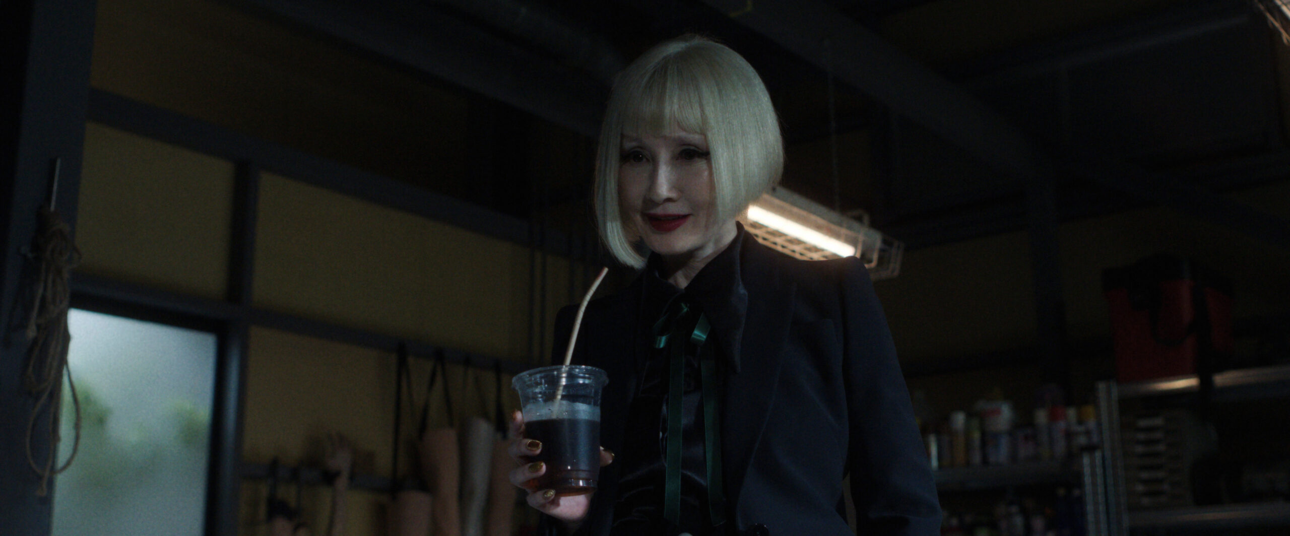 Sunny Season 1 Episode 6 Kyoto Manju So Delicious | Tell-Tale TV Hime slurps on a drink while standing in a dimly lit room on Sunny Season 1 Episode 6, "Kyoto Manju So Delicious."