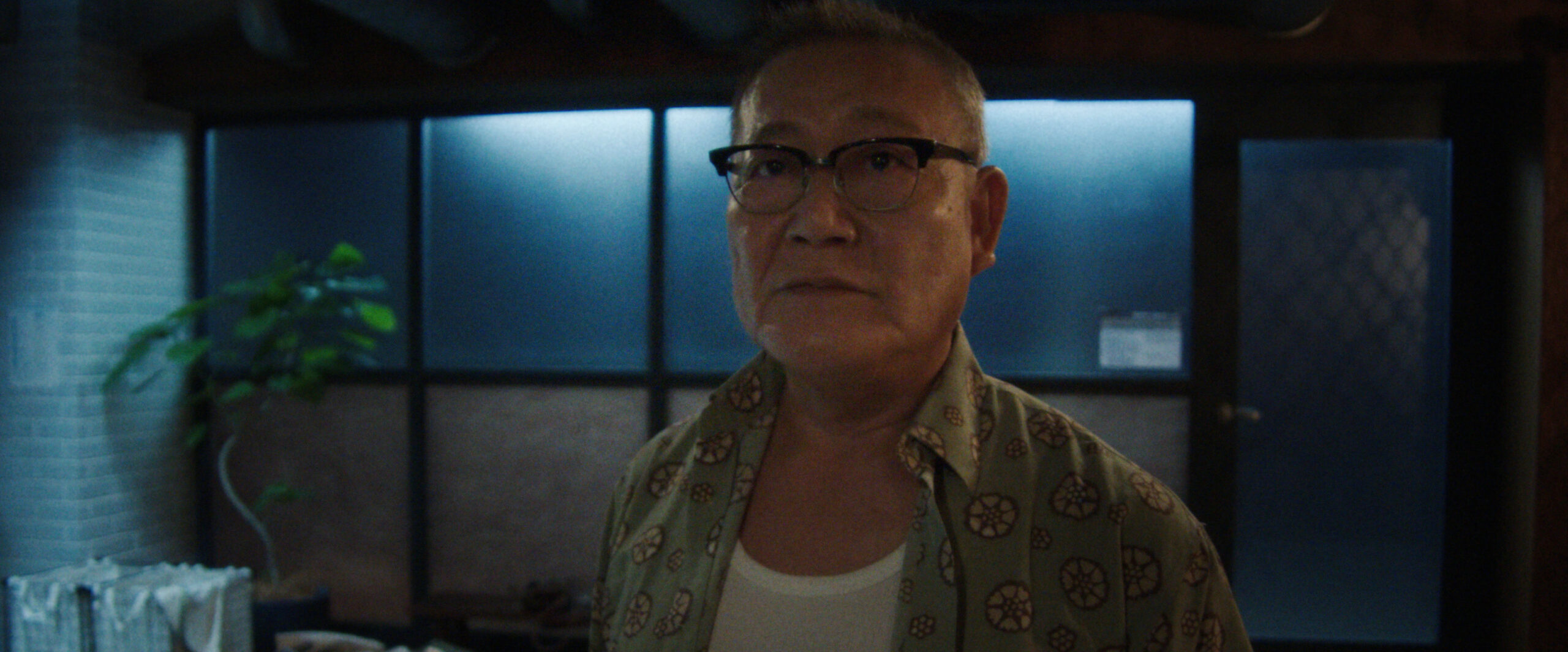 Yuki Tanaka stands in a laundry room while looking intently at something off-screen on Sunny Season 1 Episode 7, "There's Been a Shift."
