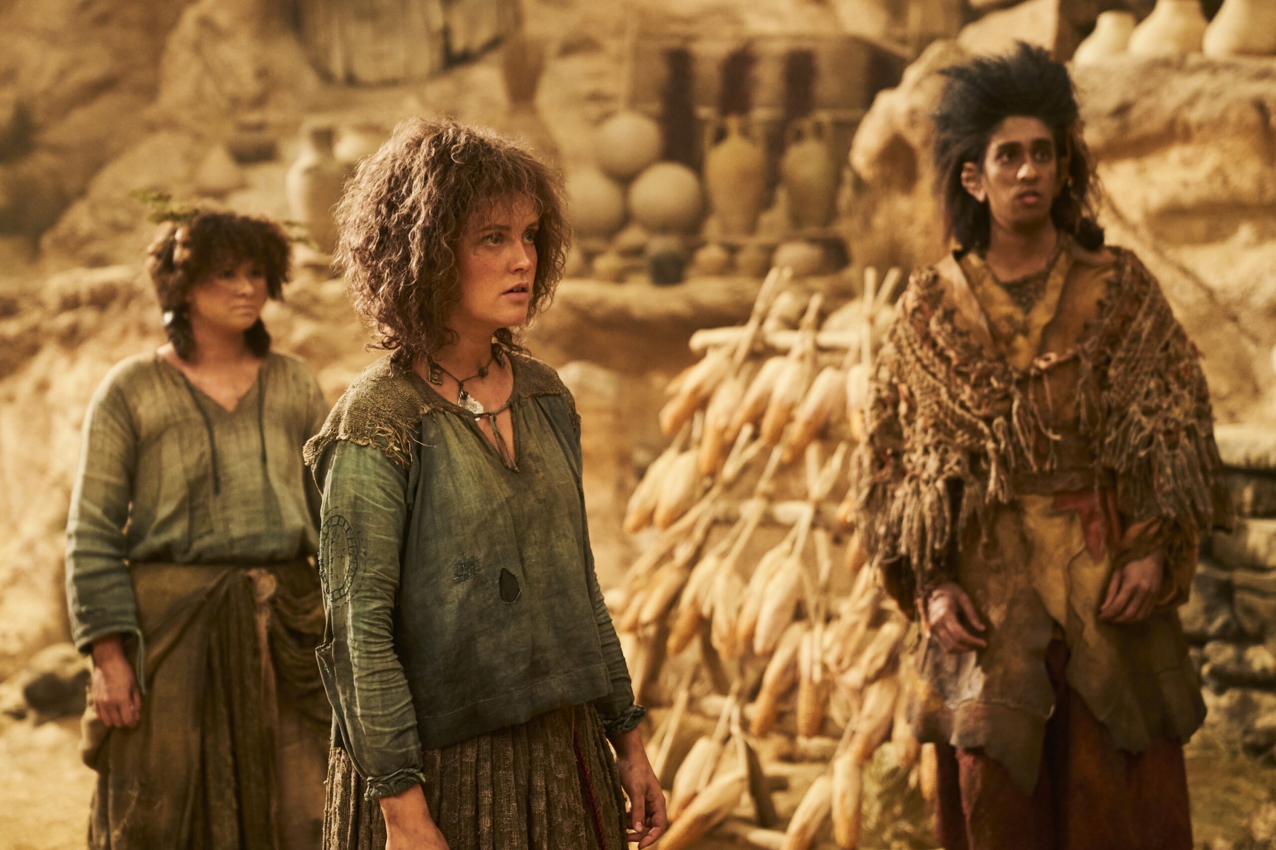 Lord of the Rings: The Rings of Power Season 2 - Megan Richards as Poppy; Markella Kavenagh as Nori; Gavi Singh Chera as Merimac | Tell-Tale TV Still from Lord of the Rings: The Rings of Power Season 2 of Megan Richards as Poppy, Markella Kavenagh as Nori, and Gavi Singh Chera as Merimac pictured from left to right.
