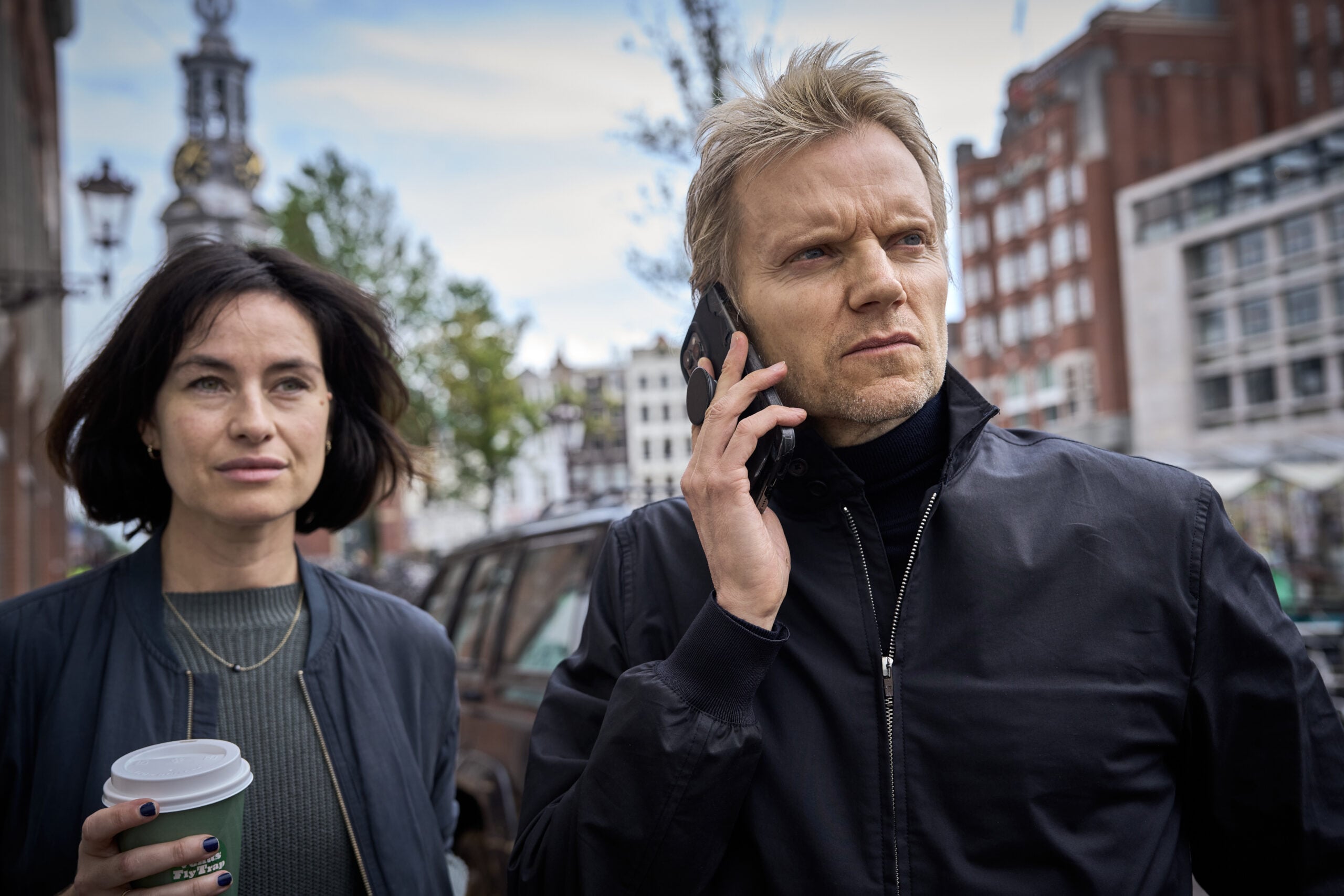 Still from VAN DER VALK Season 4 Episode 1 of Maimie McCoy as Lucienne and Marc Warren as Piet Van der Valk pictured from left to right.
