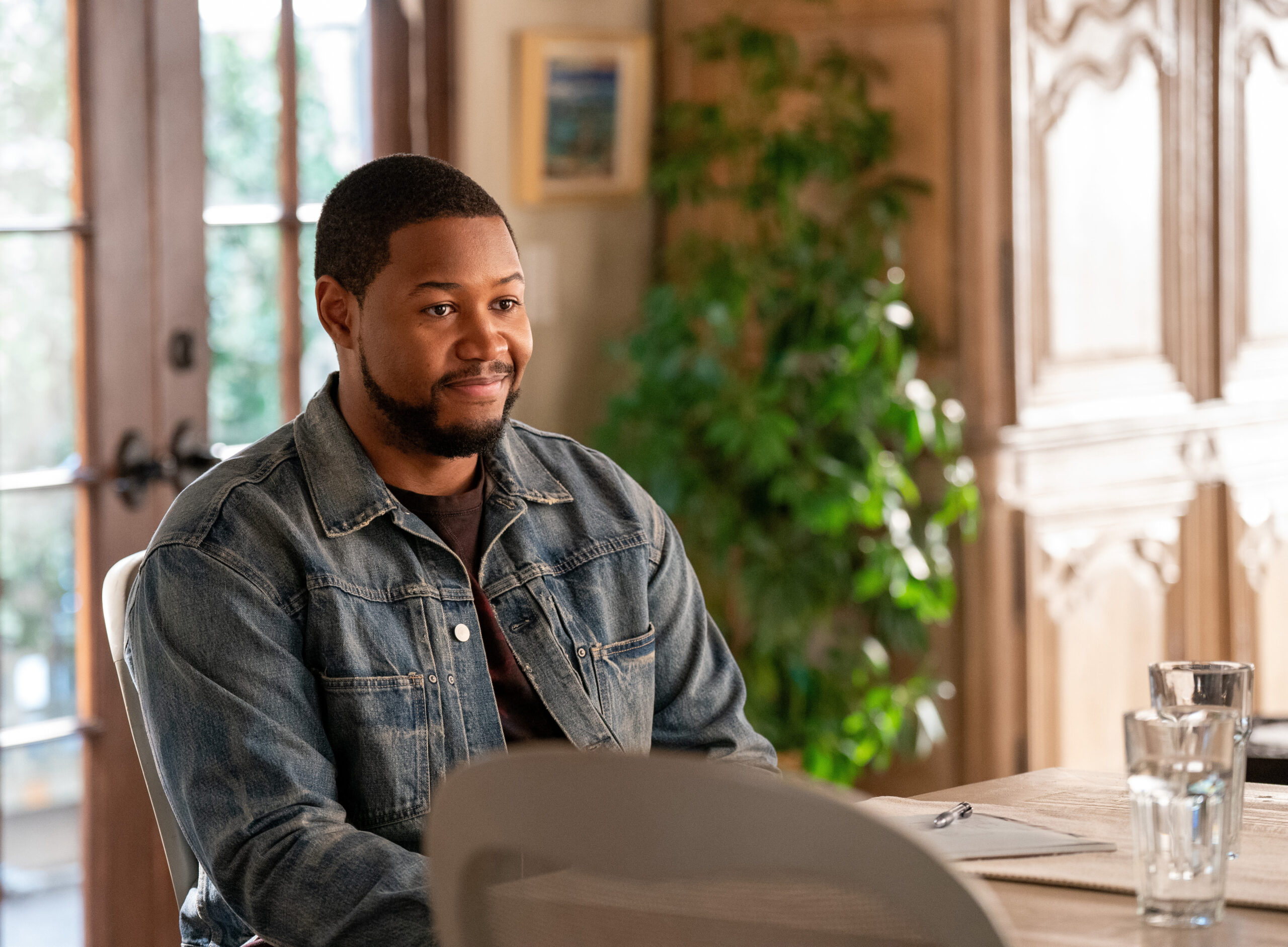 Shrinking Season 2 Episode 2 I Love Pain | Tell-Tale TV Sean sits at the island in Jimmy's kitchen while smiling on Shrinking Season 2 Episode 2, "I Love Pain."